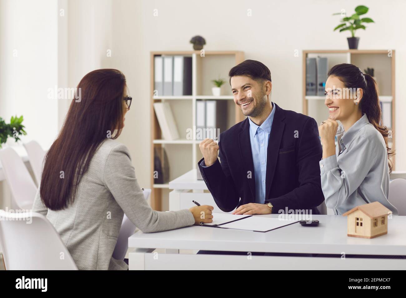 Young family happily clenching their fists at buying a house or getting mortgage approval. Stock Photo