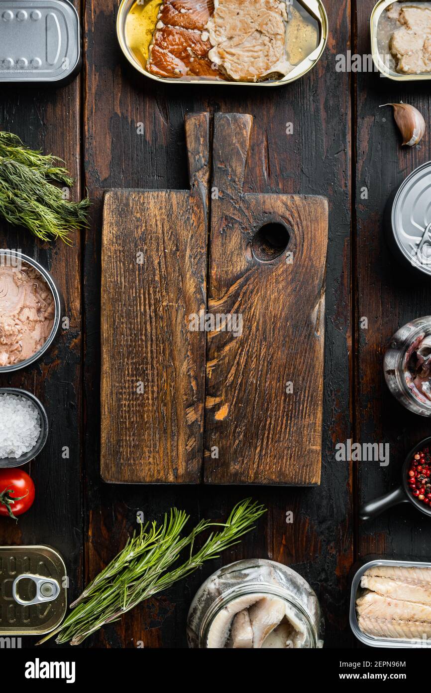 https://c8.alamy.com/comp/2EPN96M/empty-cutting-board-in-frame-of-canned-fish-sea-food-set-on-old-dark-wooden-table-background-top-view-flat-lay-with-copyspace-and-space-for-text-2EPN96M.jpg