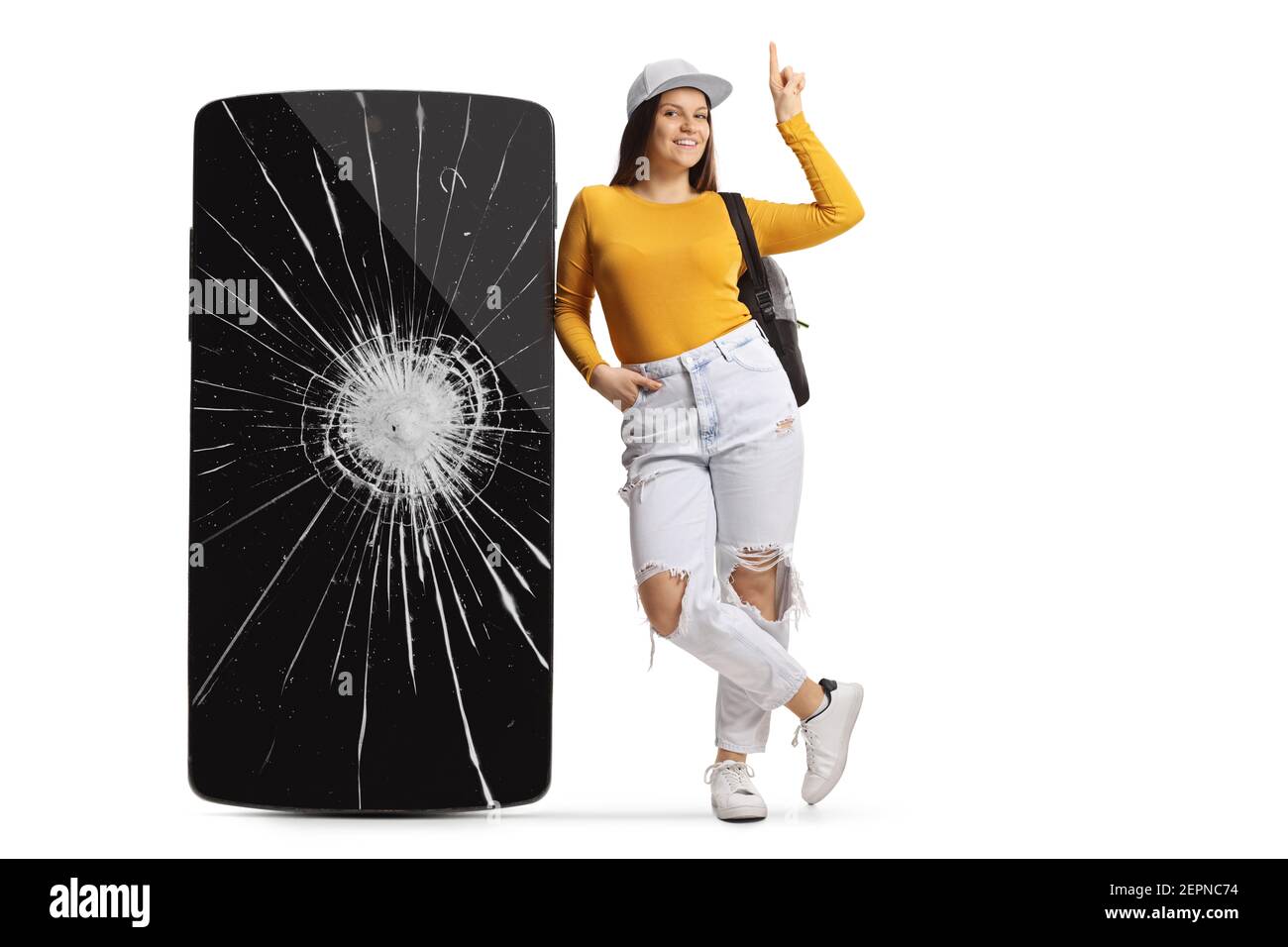 Full length portrait of a female leaning on a phone with cracked screen and pointing up isolated on white background Stock Photo