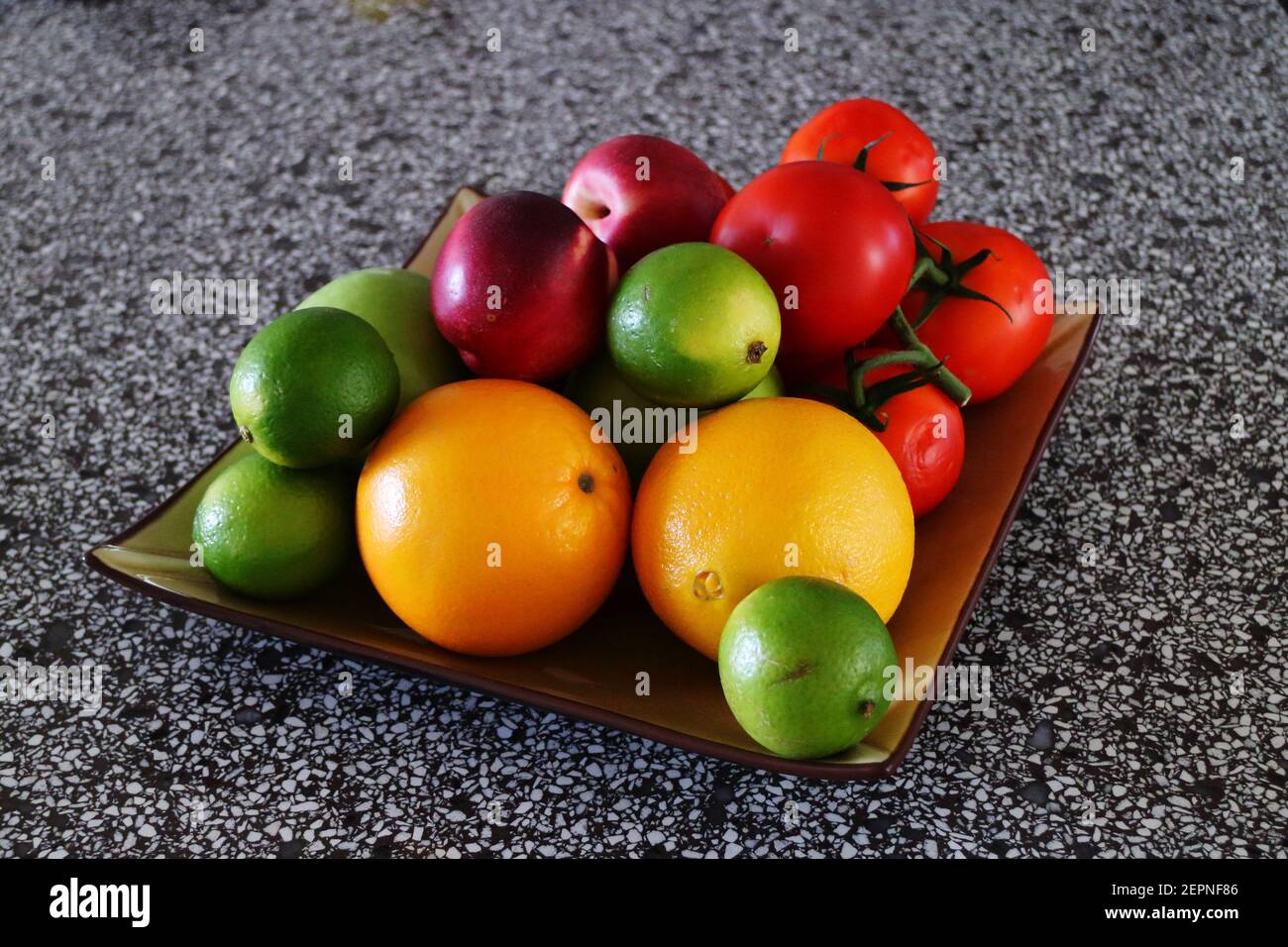 Oranges, lime, nectarines and other fruit on a platter Stock Photo