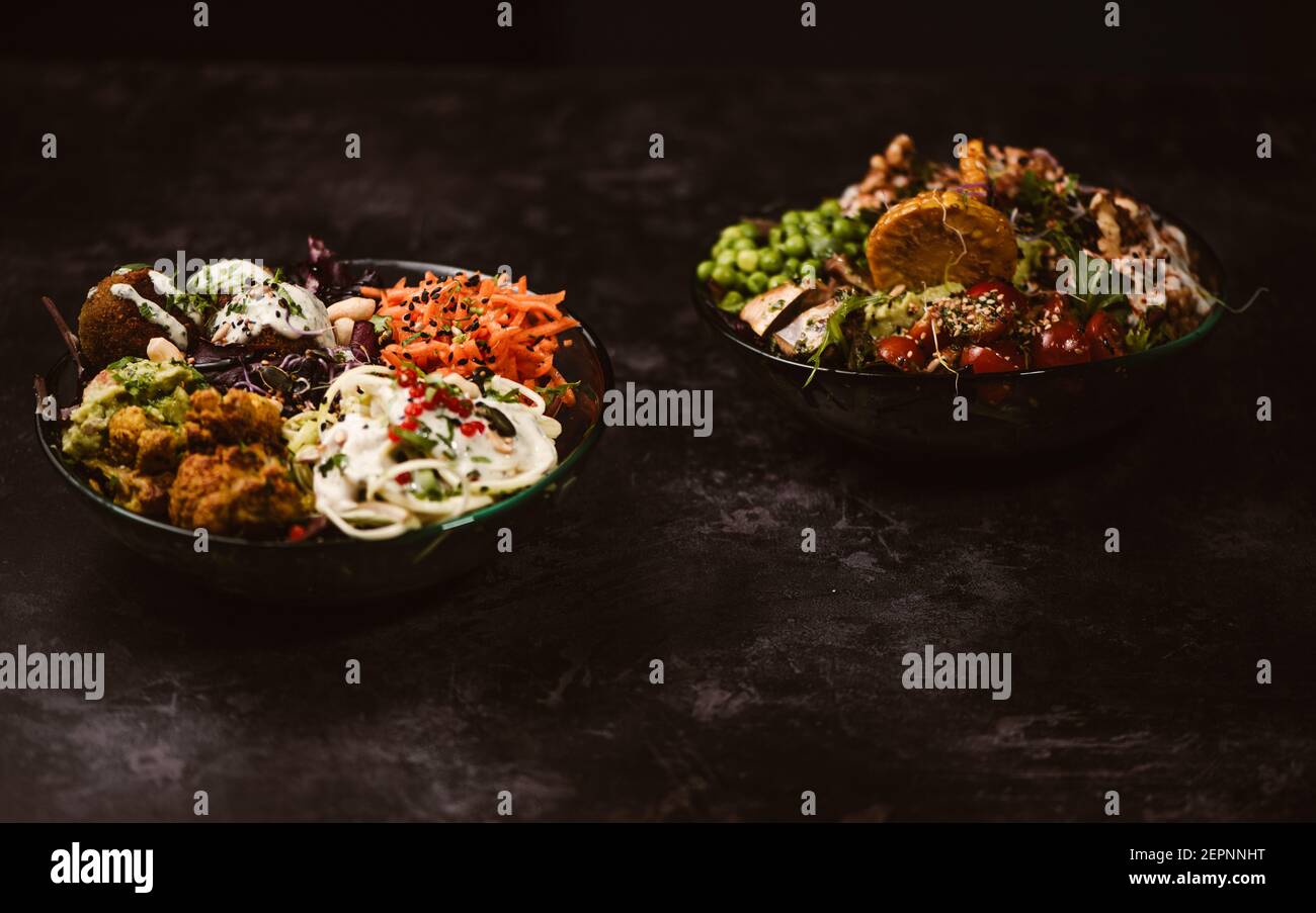 Appetizing organic vegetarian dishes with assorted vegetables on rustic dark table Stock Photo