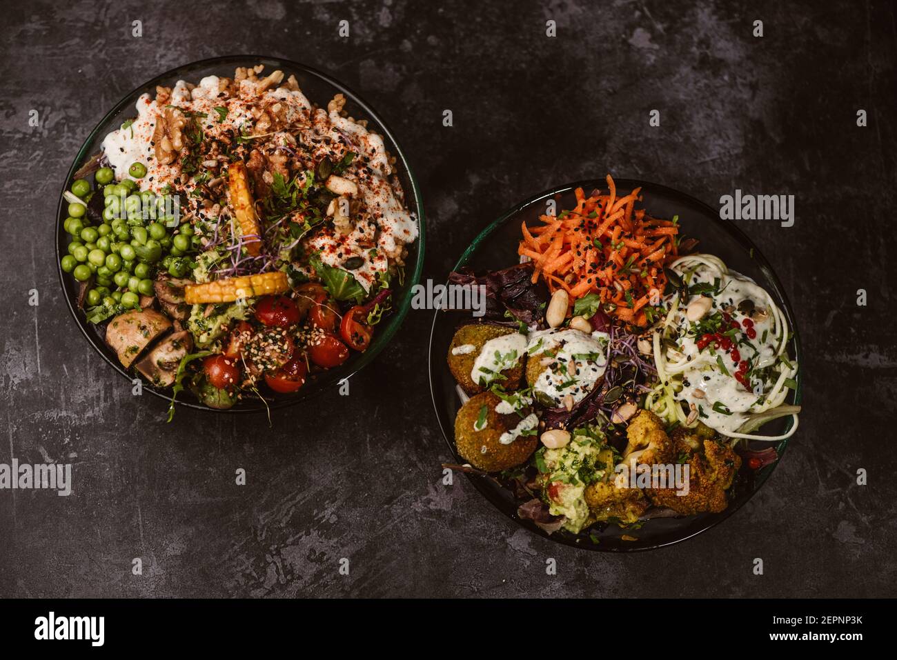 Appetizing organic vegetarian dishes with assorted vegetables on rustic dark table Stock Photo