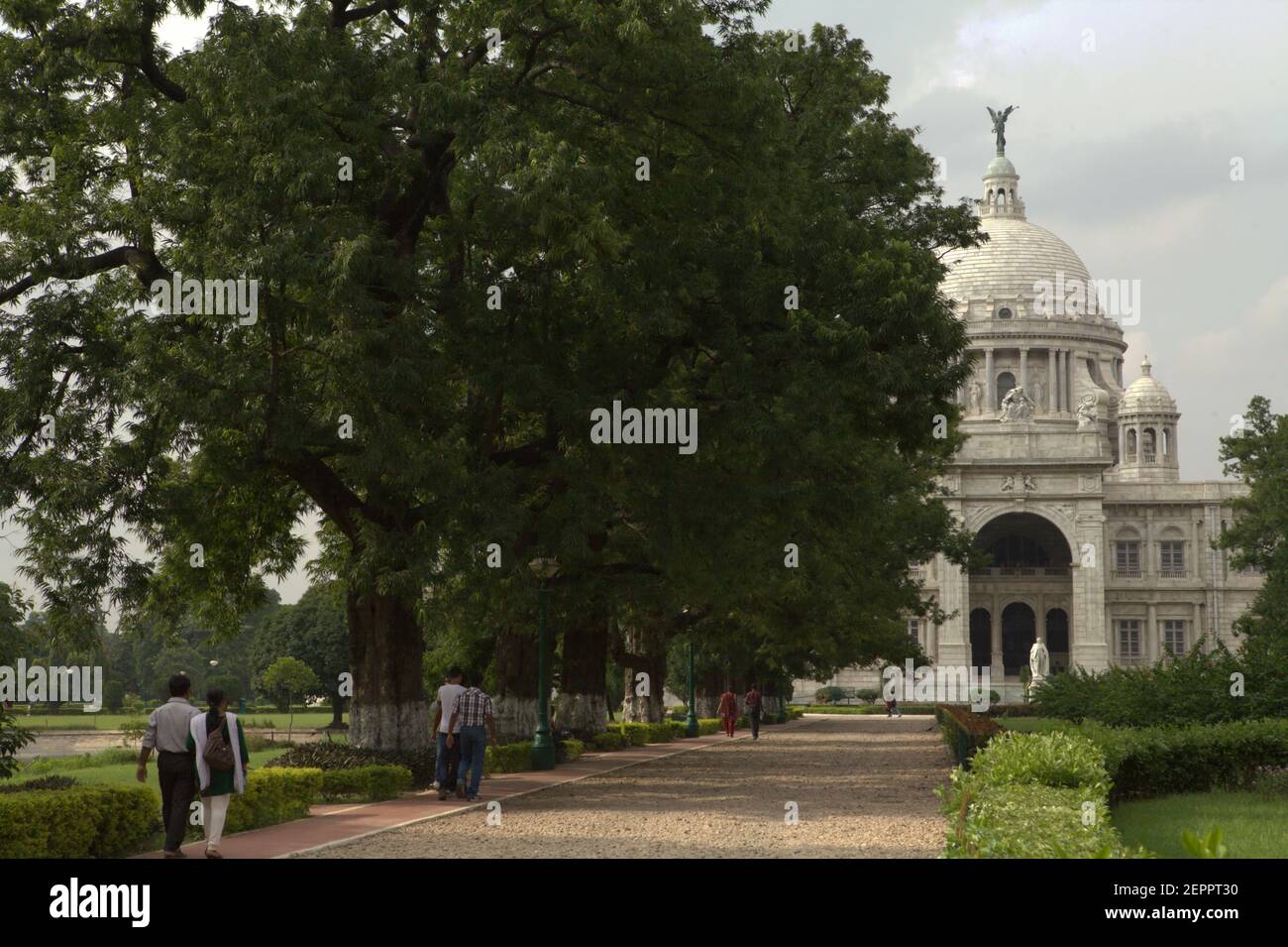 Visitors walking on a lane toward Victoria Memorial Hall in Kolkata, West Bengal, India. Stock Photo