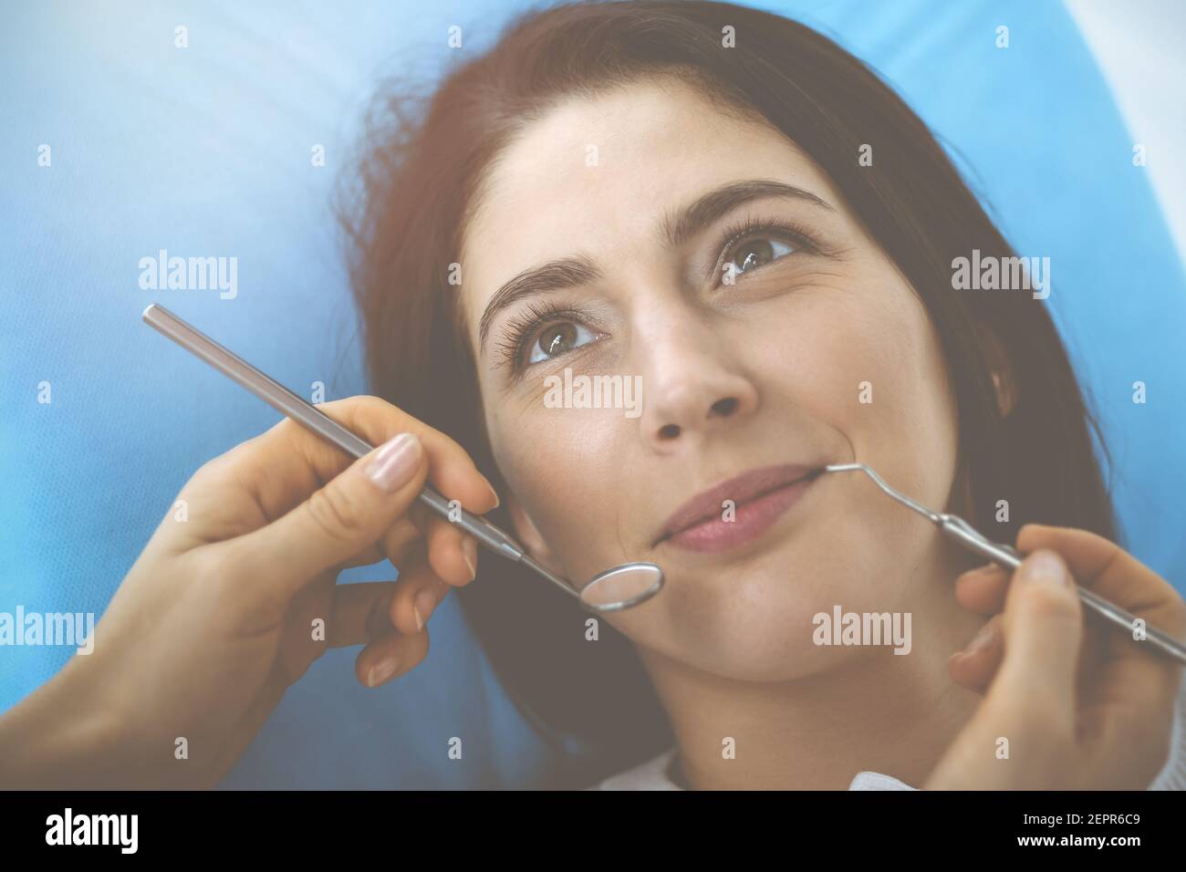 Smiling Brunette Woman Being Examined By Dentist At Dental Clinic