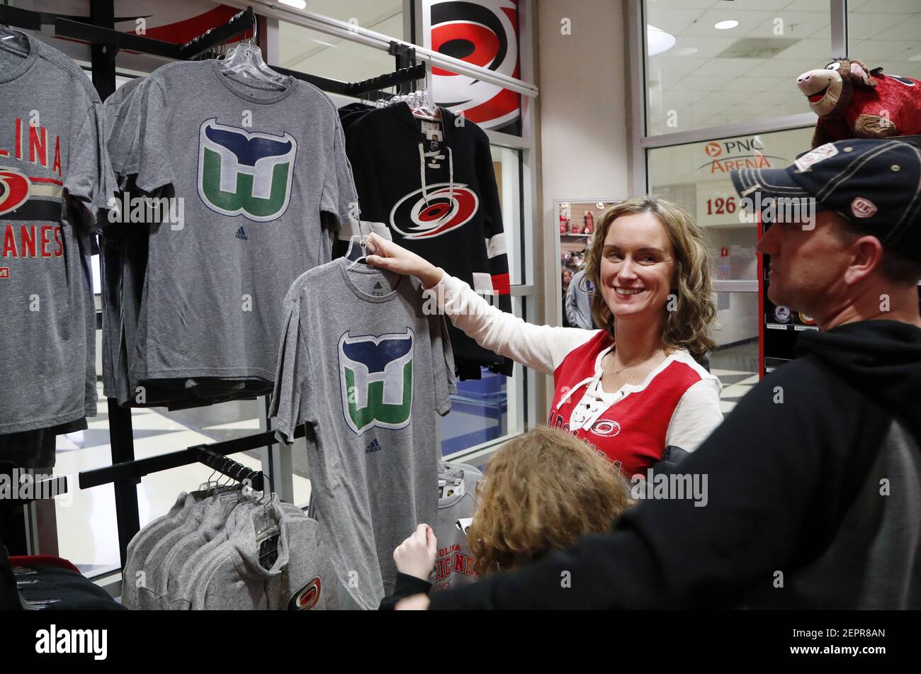 Sales clerk Melanie Crete, left, bags up a Hartford Whalers T-shirt for Carolina  Hurricanes fans Lawrence Miller, second from right, his wife Jennifer  Miller, right, and their daughter Avery Miller, 9, at