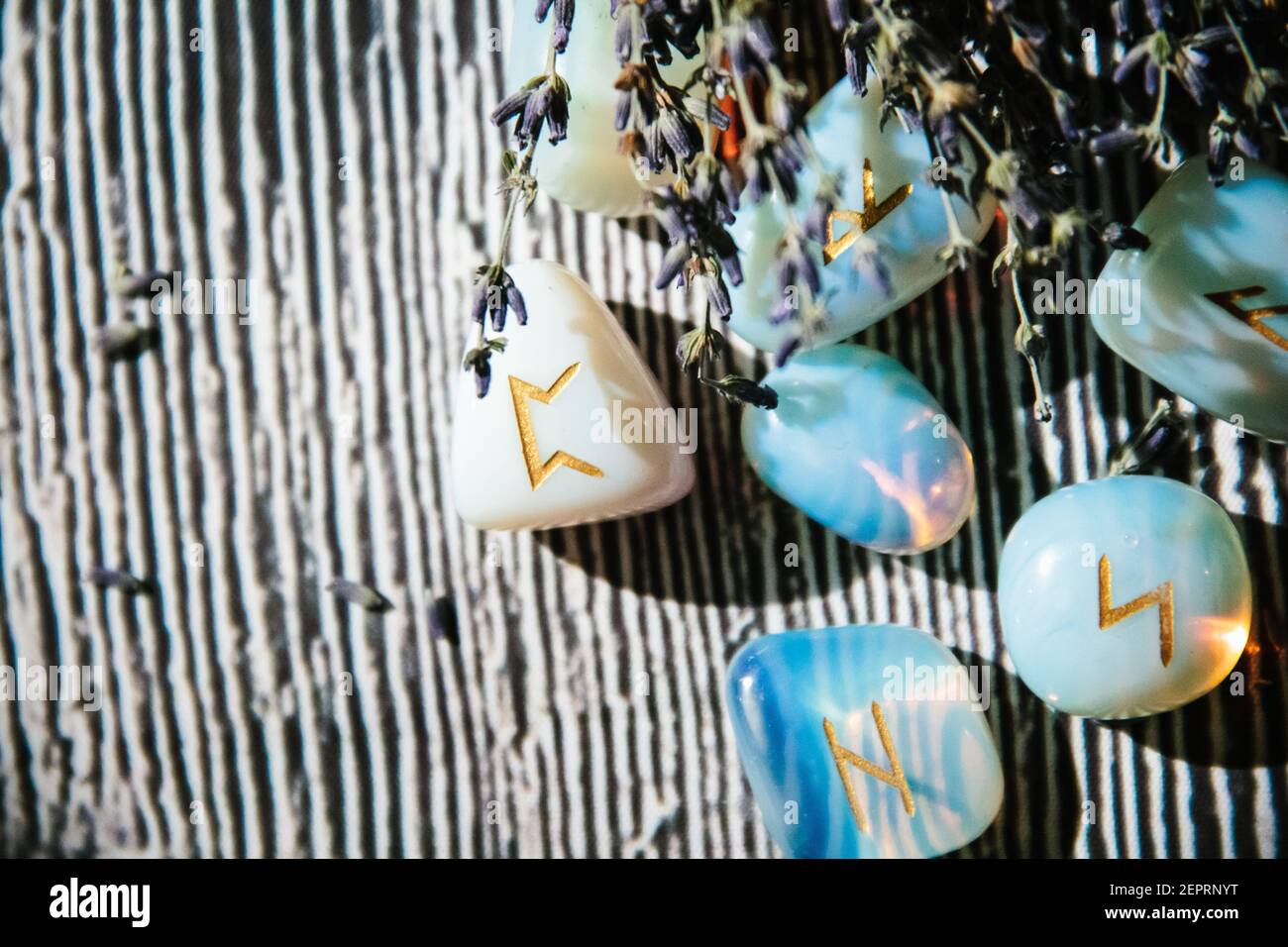 Close up of wooden table with occult attributes. Rune stones, candles ...