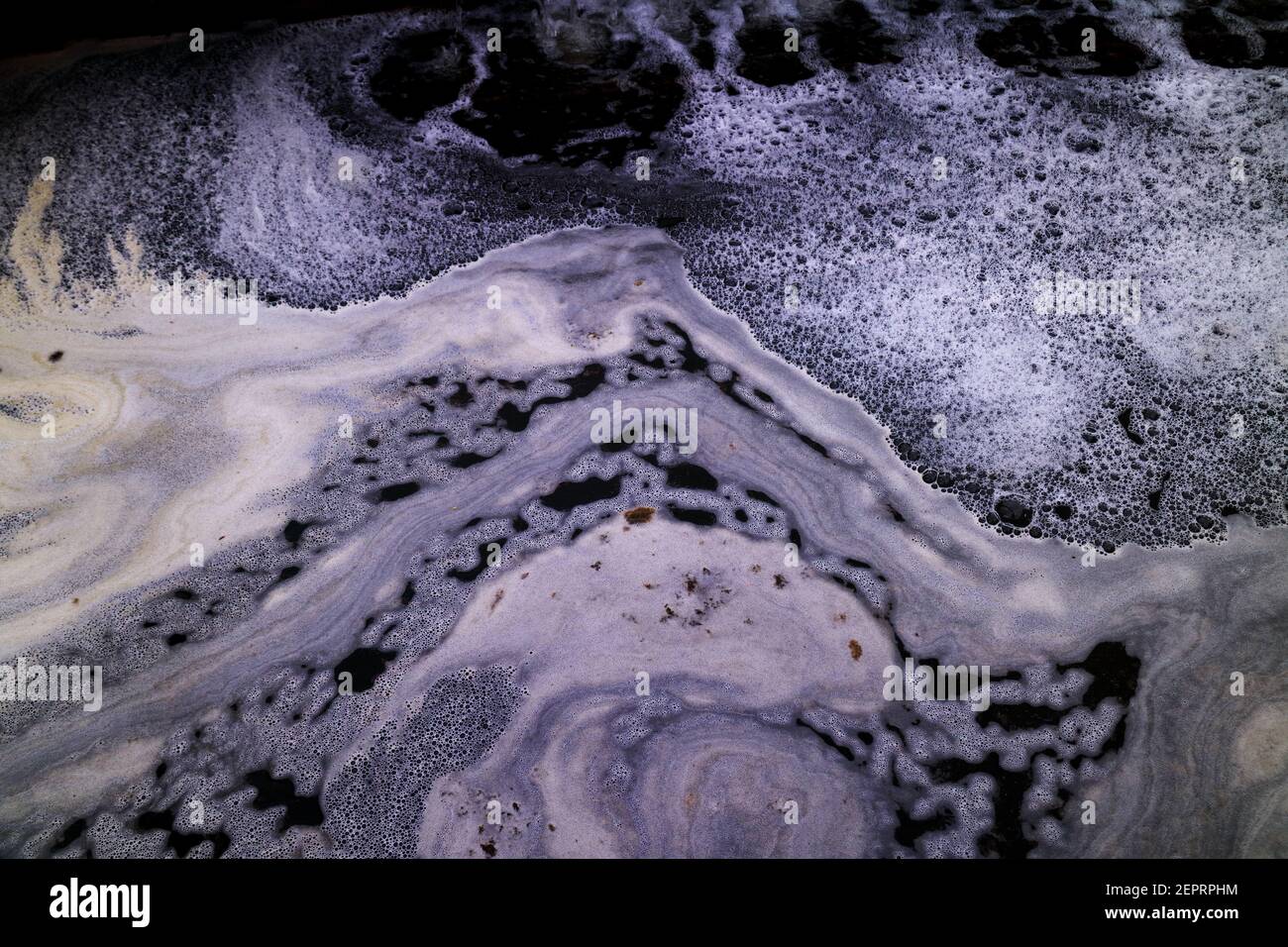 Close up of white foam and bubbles in blue water in Brisbane River