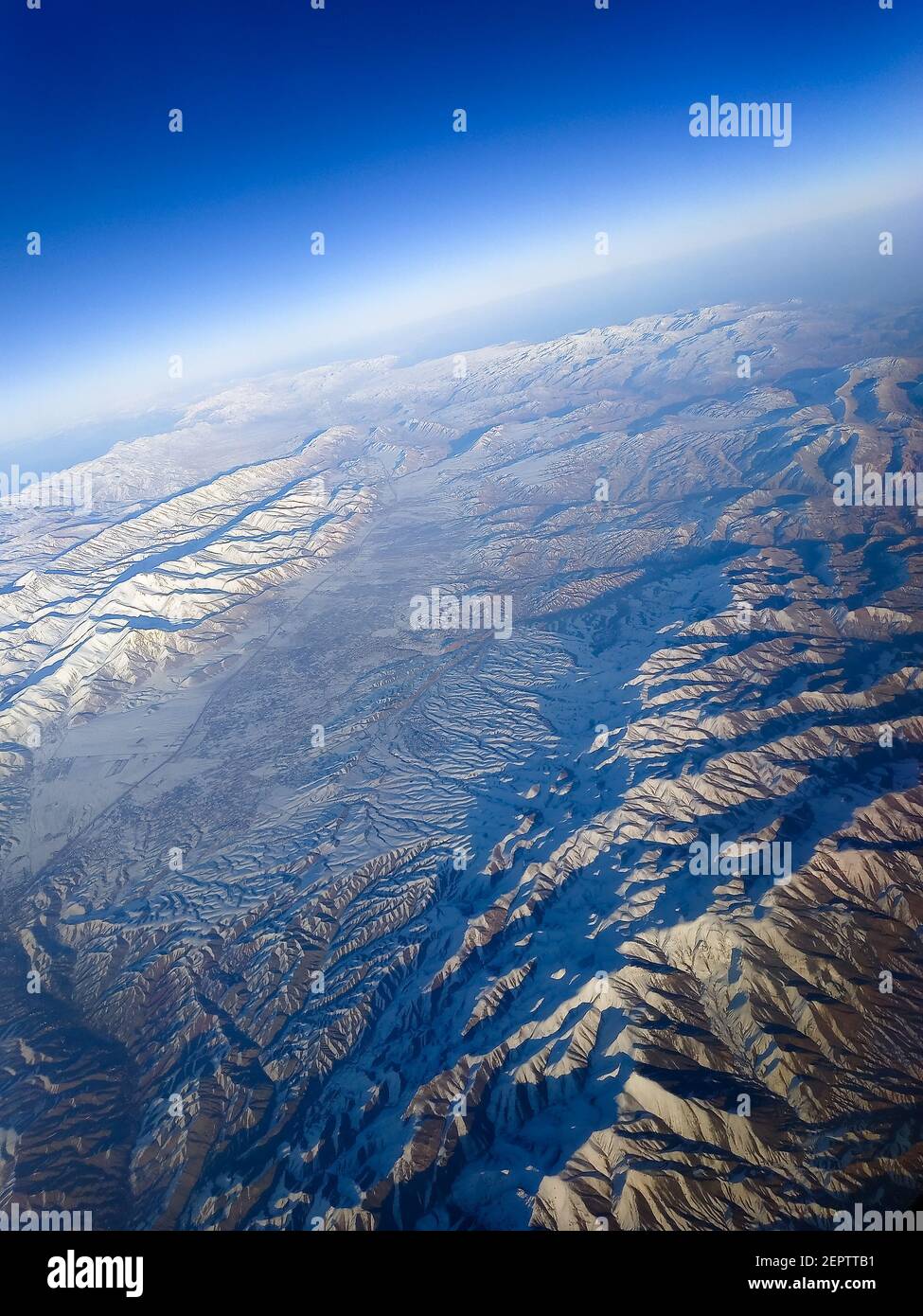 Beautiful view of the earth from the porthole of an airplane. The mountains. Stock Photo