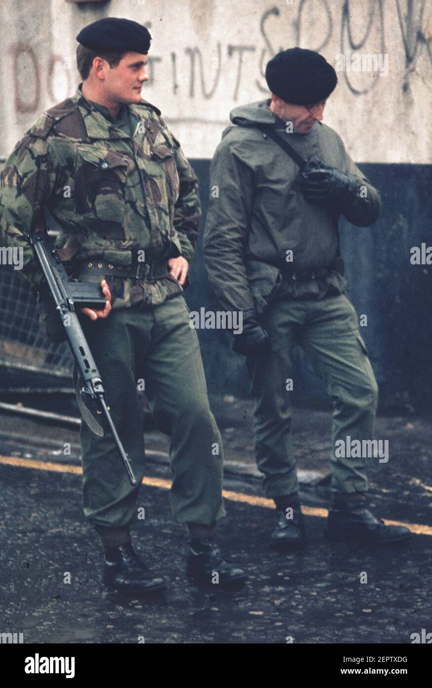 Two armed soldiers patrolling the streets in downtown Belfast during the troubles in the 70s, Northern Ireland Stock Photo