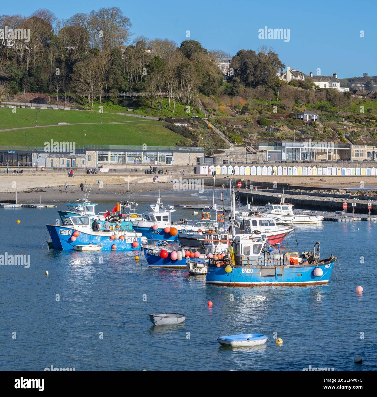 Lyme Regis, Dorset, UK. 28th Feb, 2021. UK Weather: Brightly coloured fishing boats in the harbour at the seaside resort of Lyme Regis on a morning of bright spring sunshine and clear blue skies. Credit: Celia McMahon/Alamy Live News Stock Photo