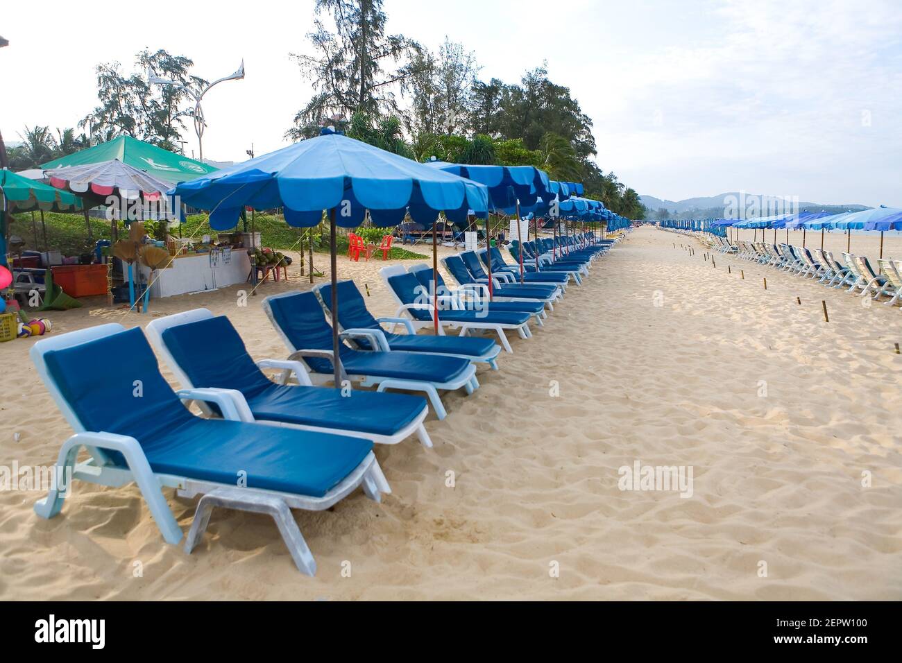 Deserted Karon Beach in Phuket with umbrellas and sun loungers. Thailand. Stock Photo