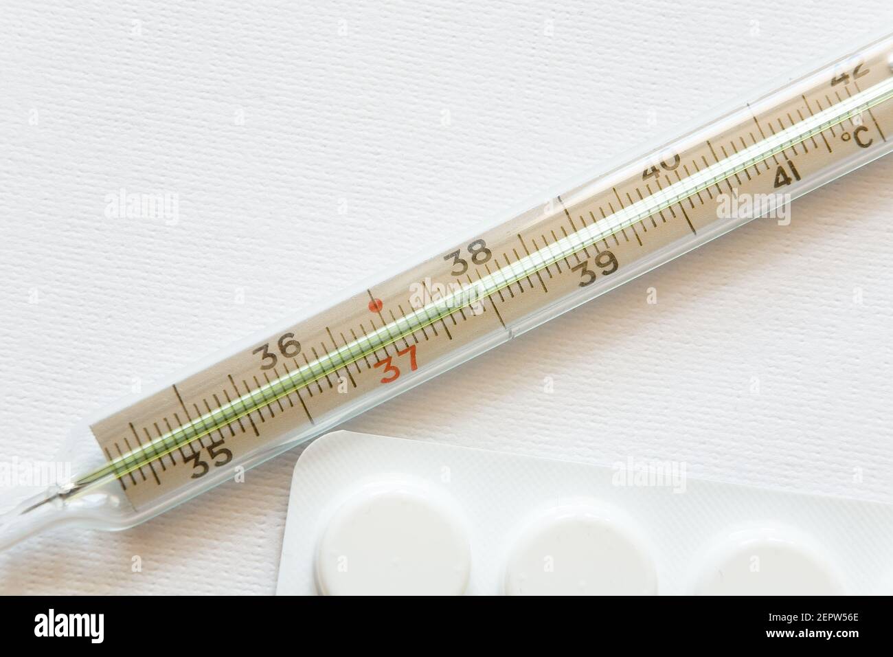 Medical thermometer and pills closeup. Medicine and health. Stock Photo
