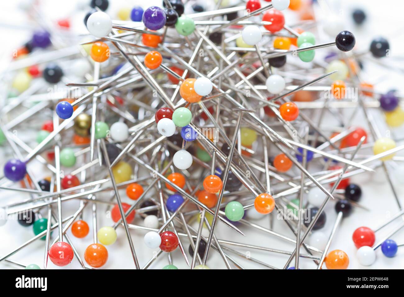 Heap of multi-coloured sewing pins on a white background, Stock image