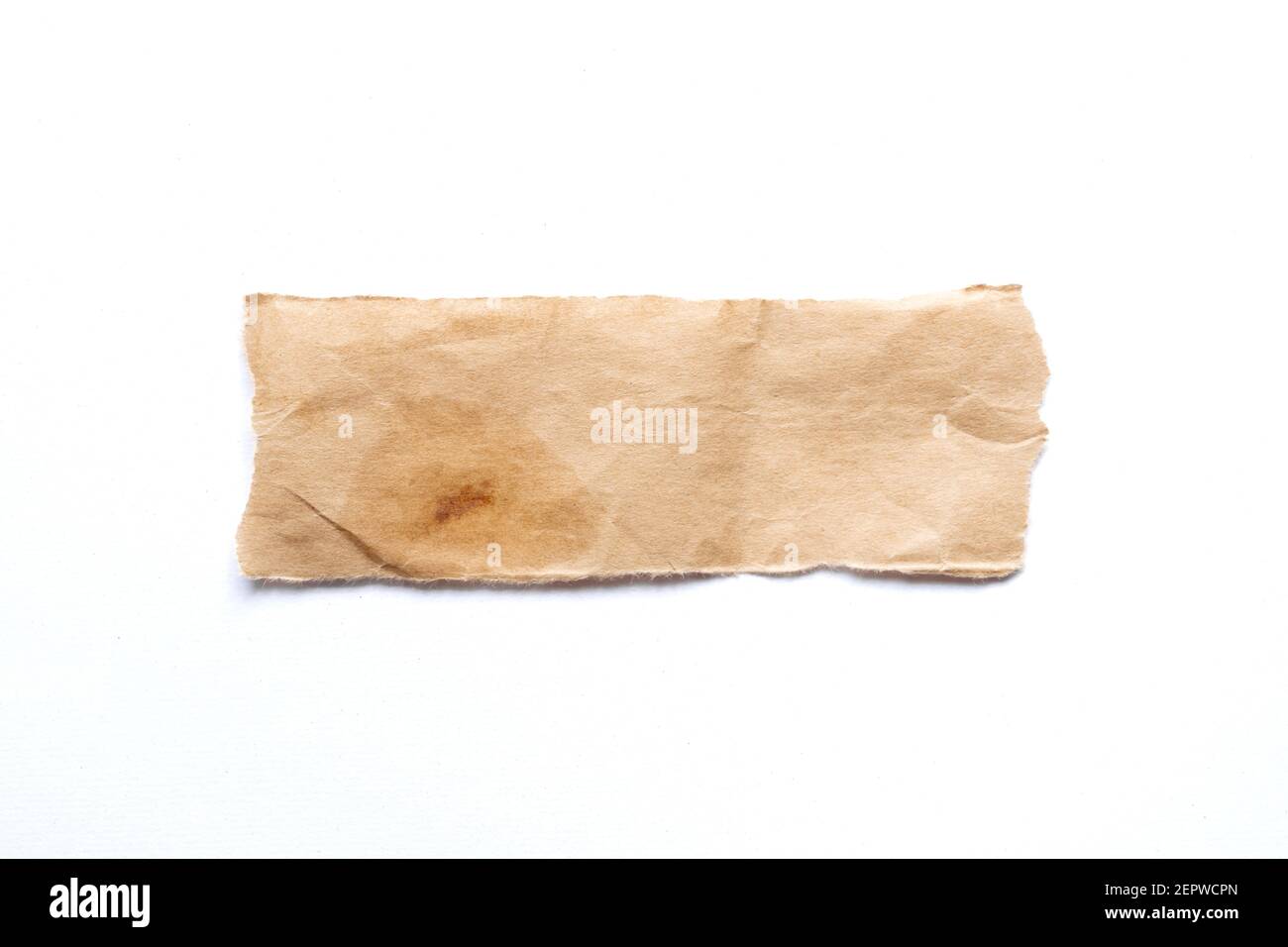 close up of a ripped piece of brown spaper on white background Stock Photo