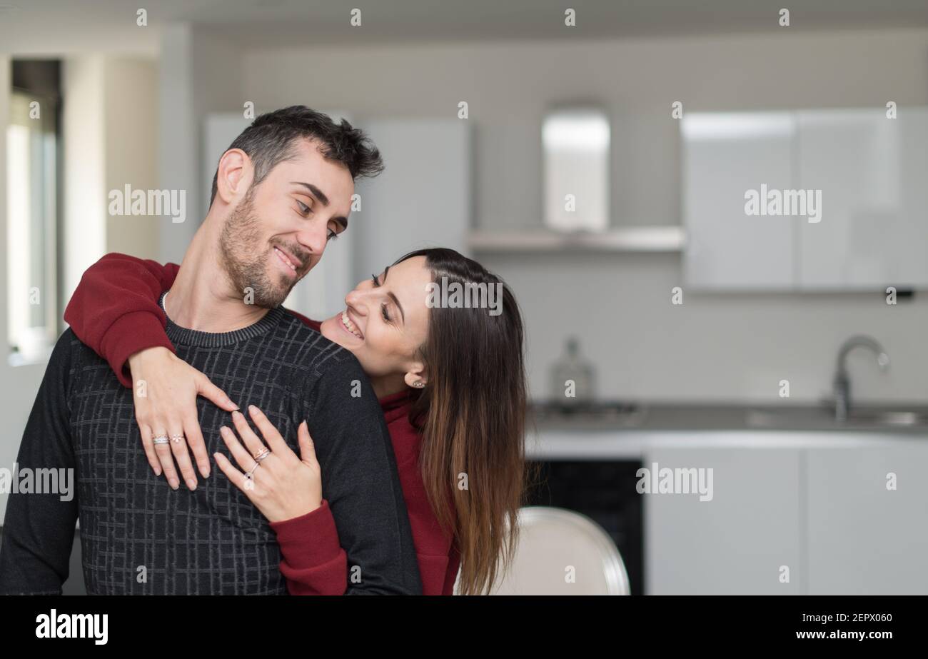 Happy couple hugging in their home Stock Photo - Alamy