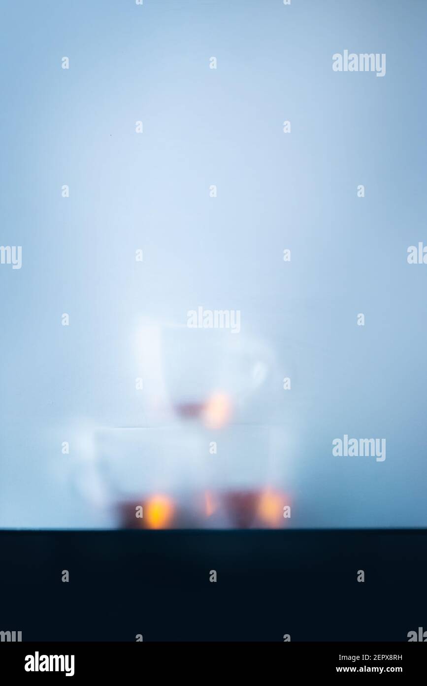 Glass teacups pyramid behind a matte glass, cold morning atmosphere Stock Photo