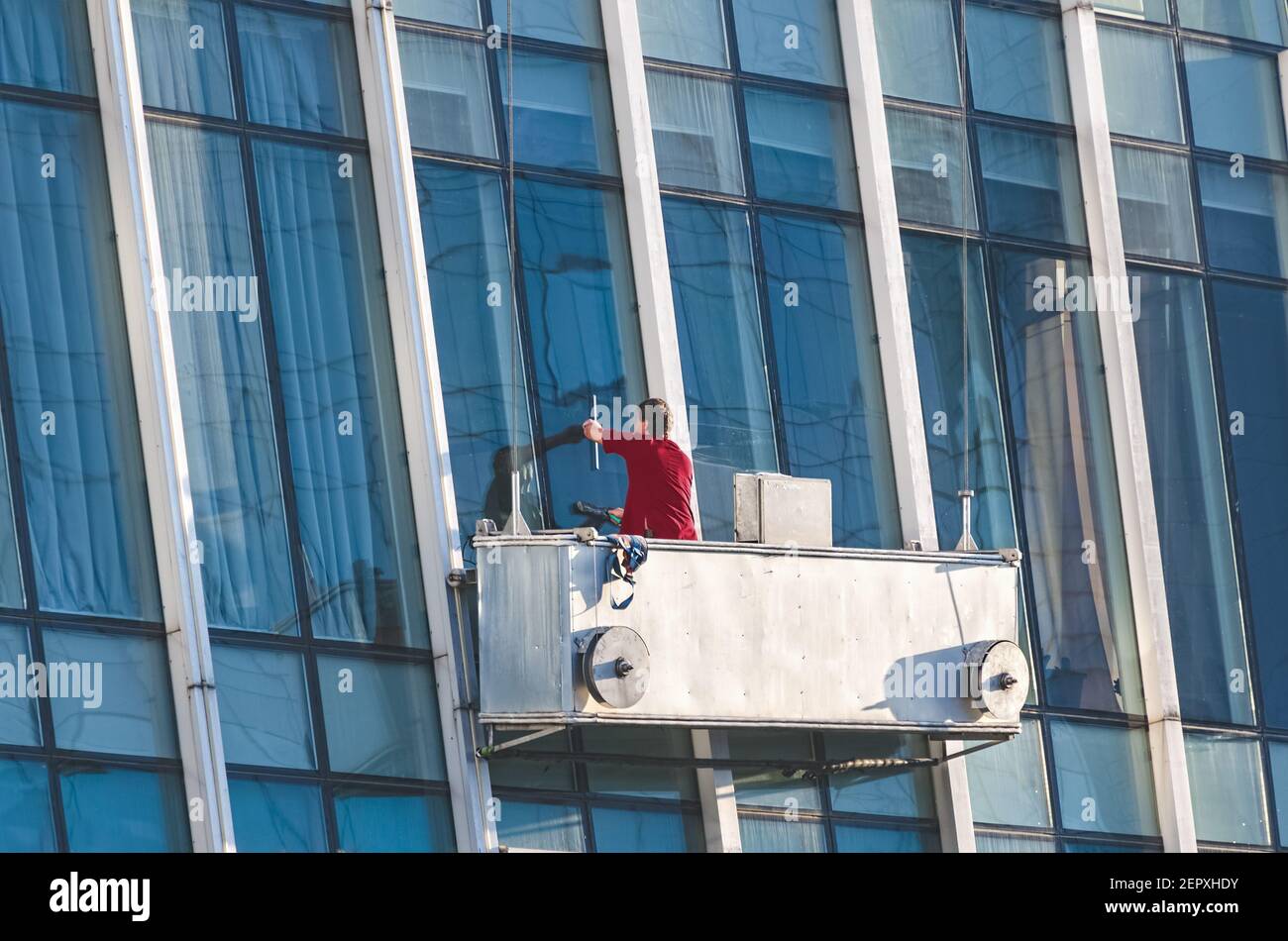 Window washer cleaning the glass facade of an office building