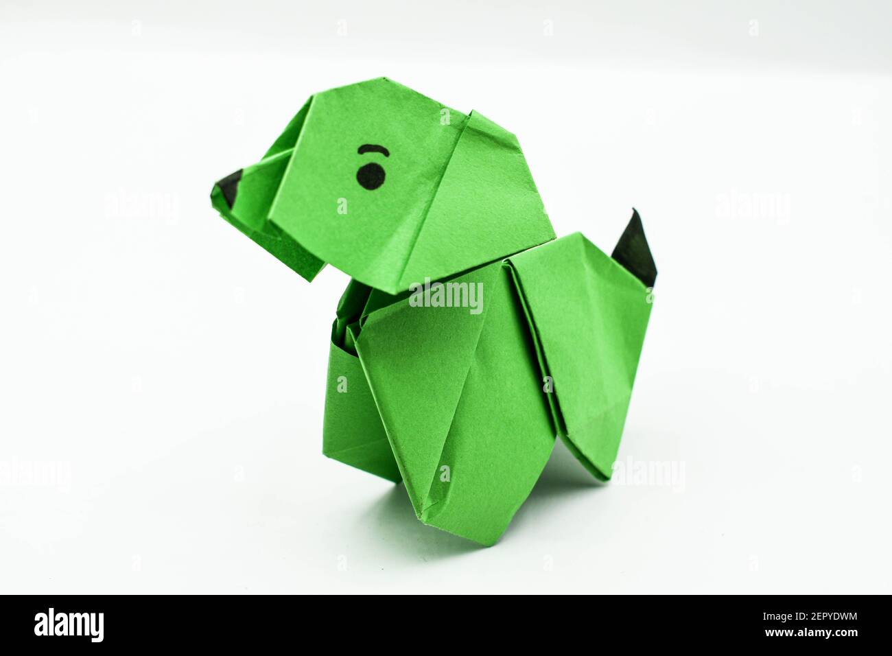 Green origami dog isolated on white background.Satisfying art with paper. Stock Photo