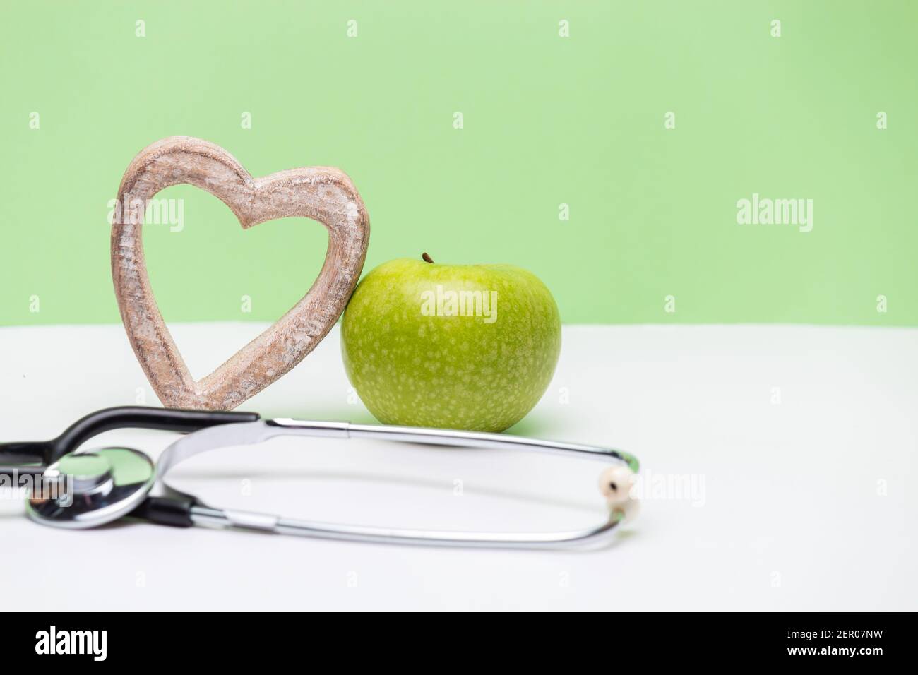 Apple, heart and stethoscope on horizontal green and white background ...