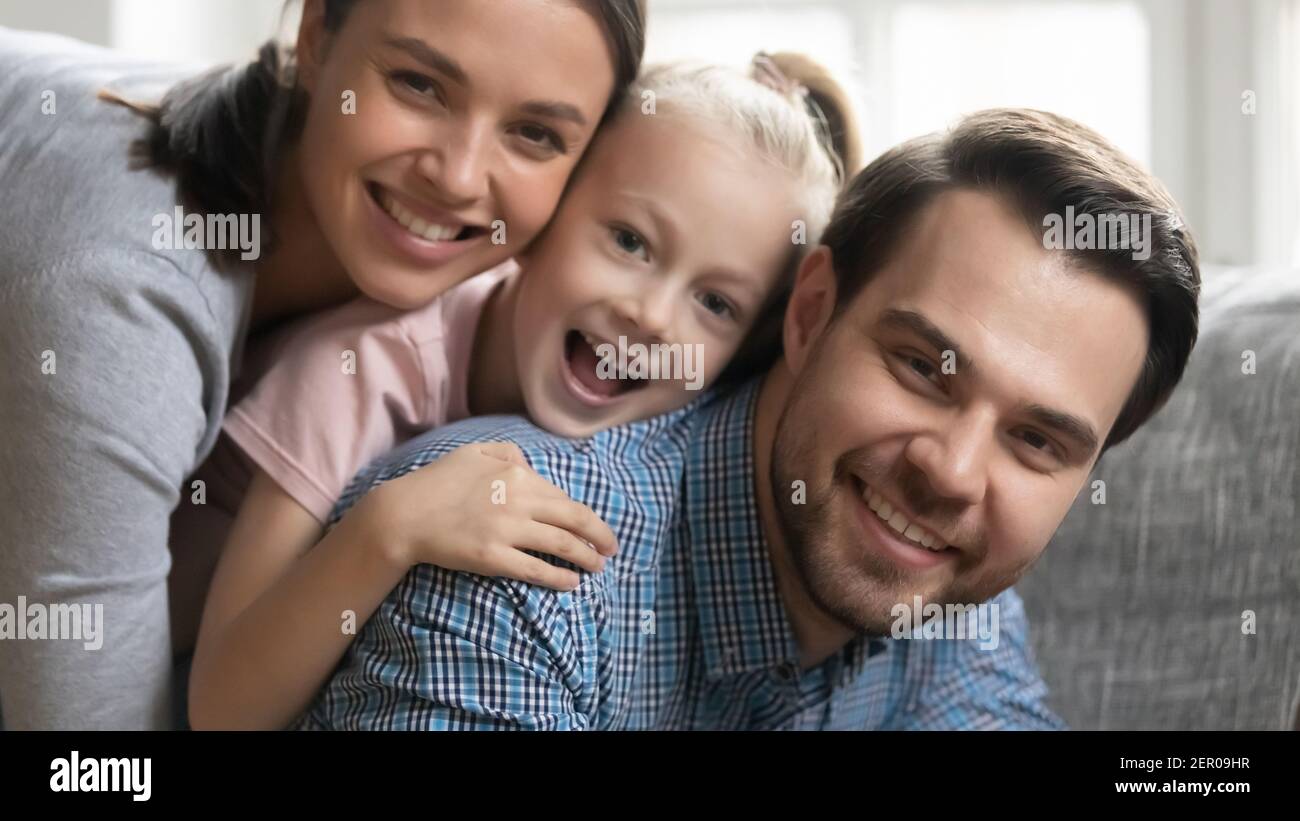 Portrait of cute happy family stacked on couch Stock Photo