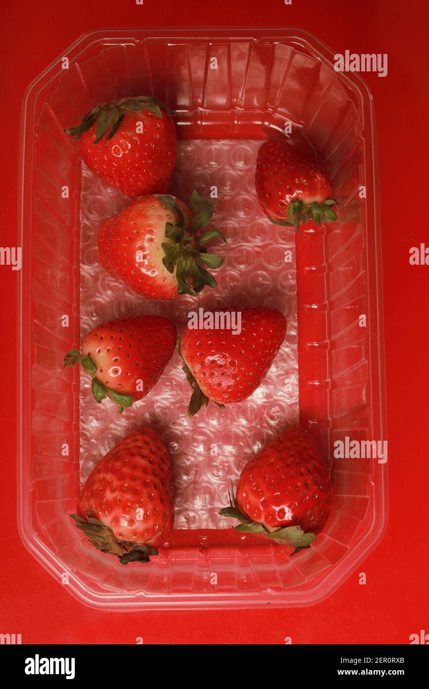 plastic supermarket container with few strawberries Stock Photo