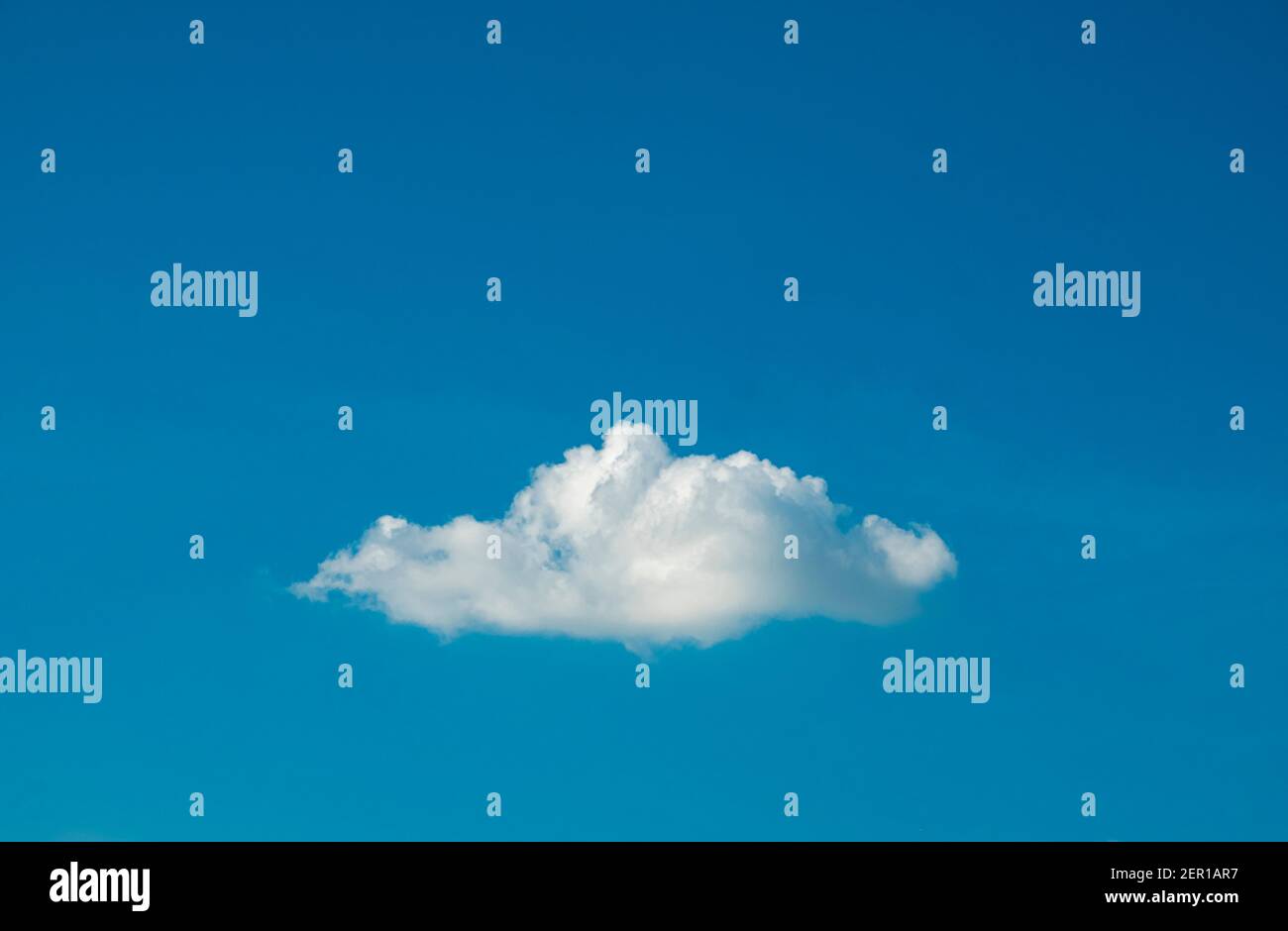 Cute white fluffy single cloud on clear blue sky background. Stock Photo