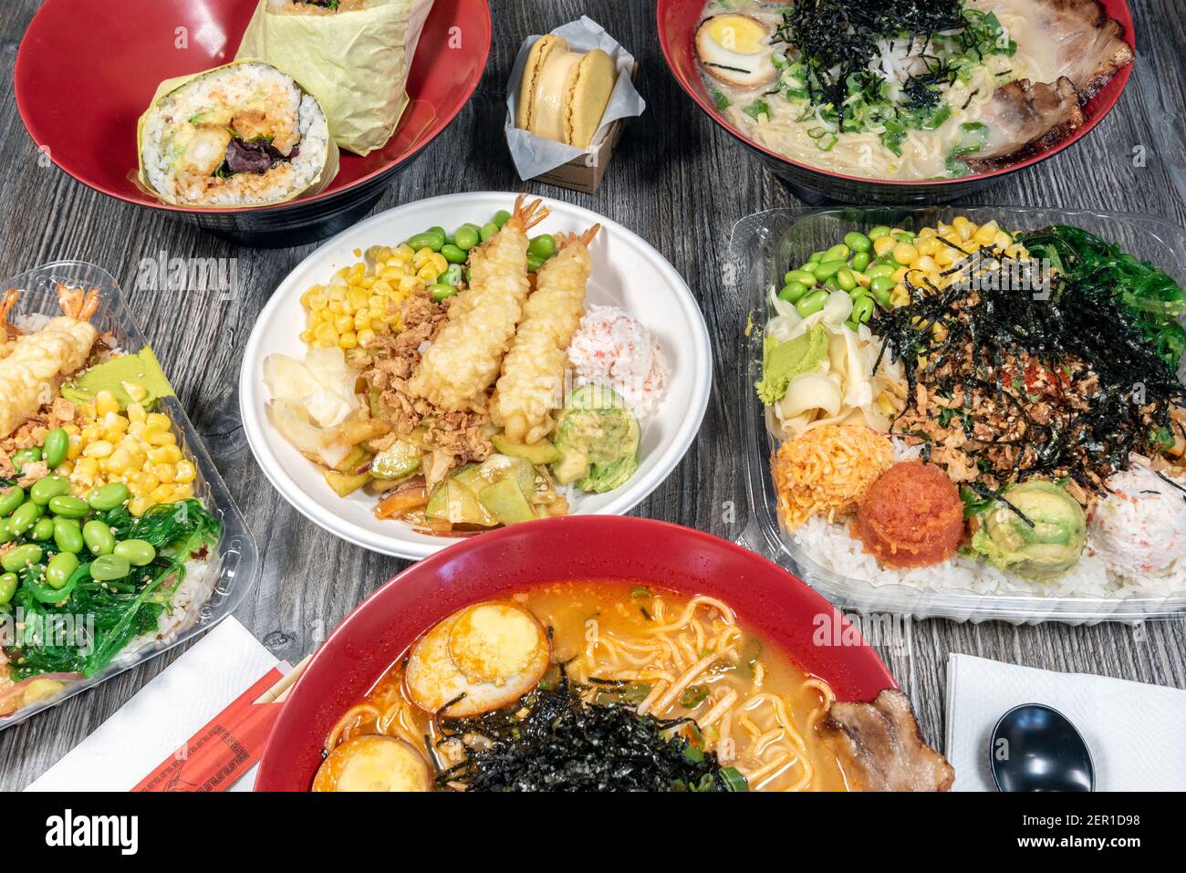 Small bowl of poke topped with shrimp tempura, crab meat, edemame, and corn served up and ready to eat. Stock Photo
