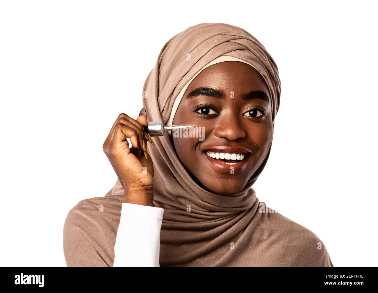 Muslim black lady applying moisturizer or hyaluronic acid on face Stock Photo
