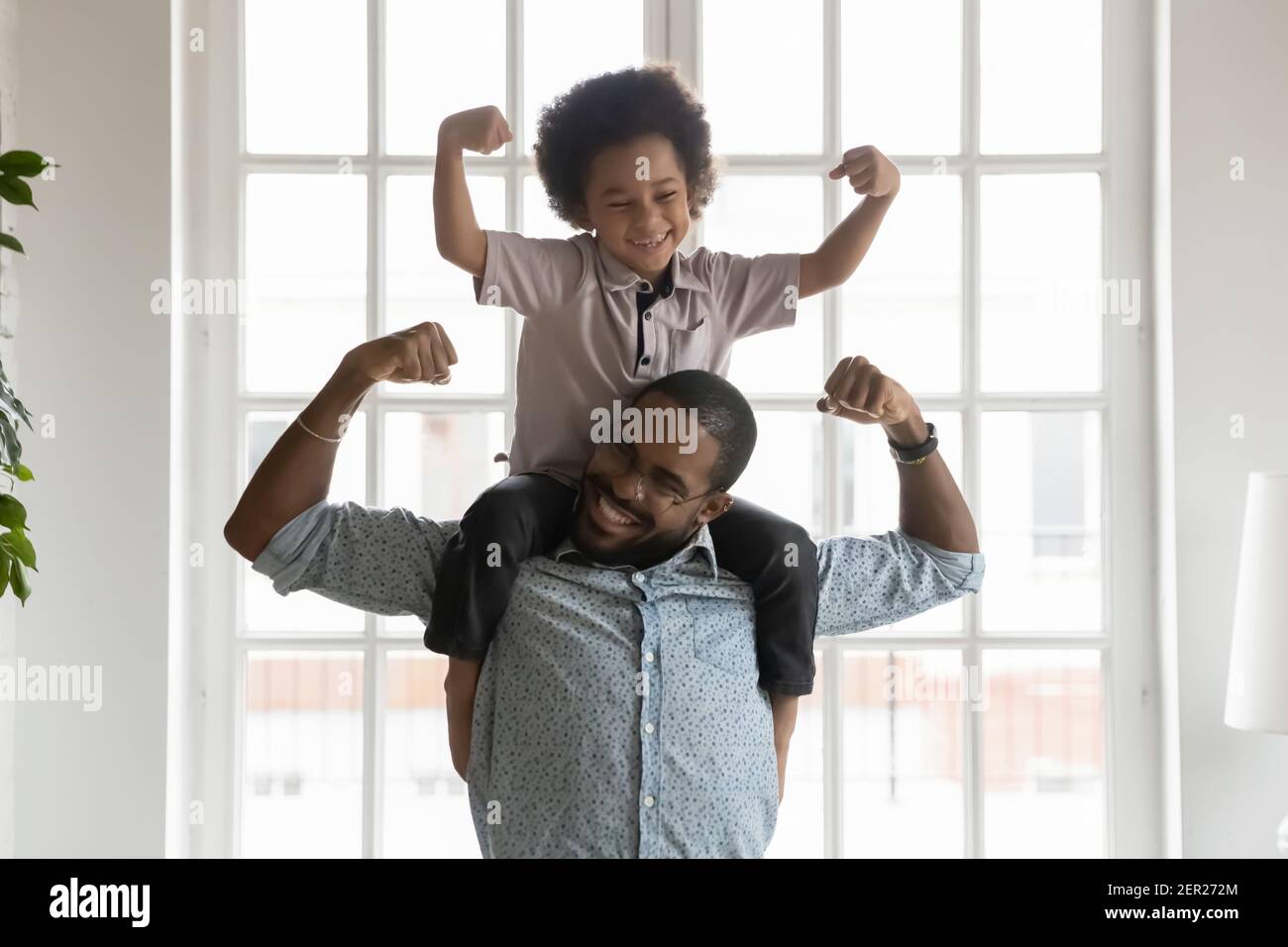 Happy funny kid riding on dads shoulders Stock Photo
