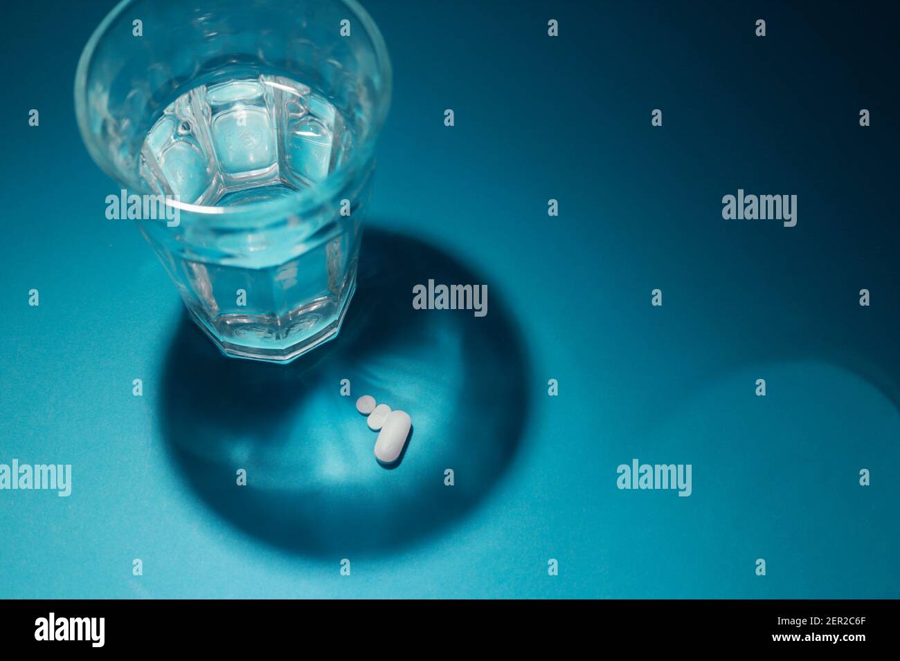 glass of water with stripes on the bottom and tablets Stock Photo