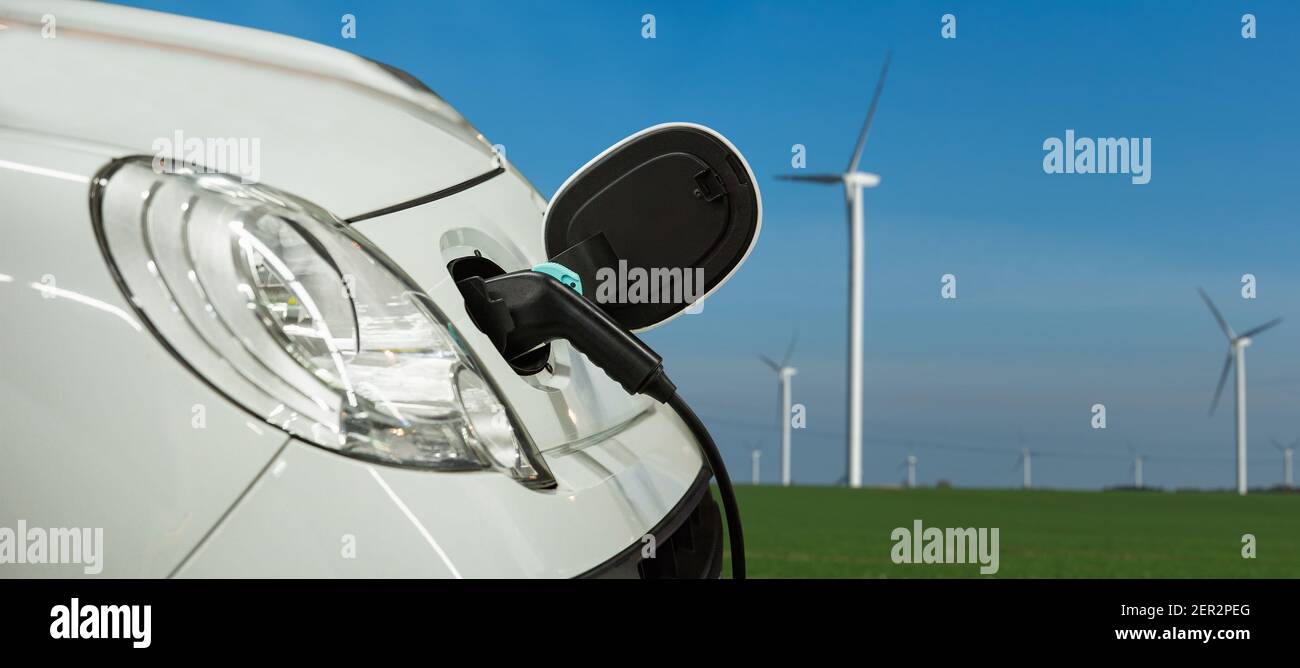Electric car on a background of wind turbines Stock Photo Alamy