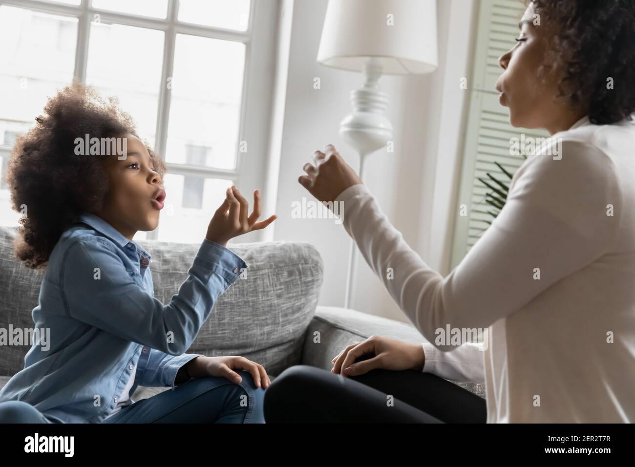 Excited African American kid talking to mom nonverbal Stock Photo