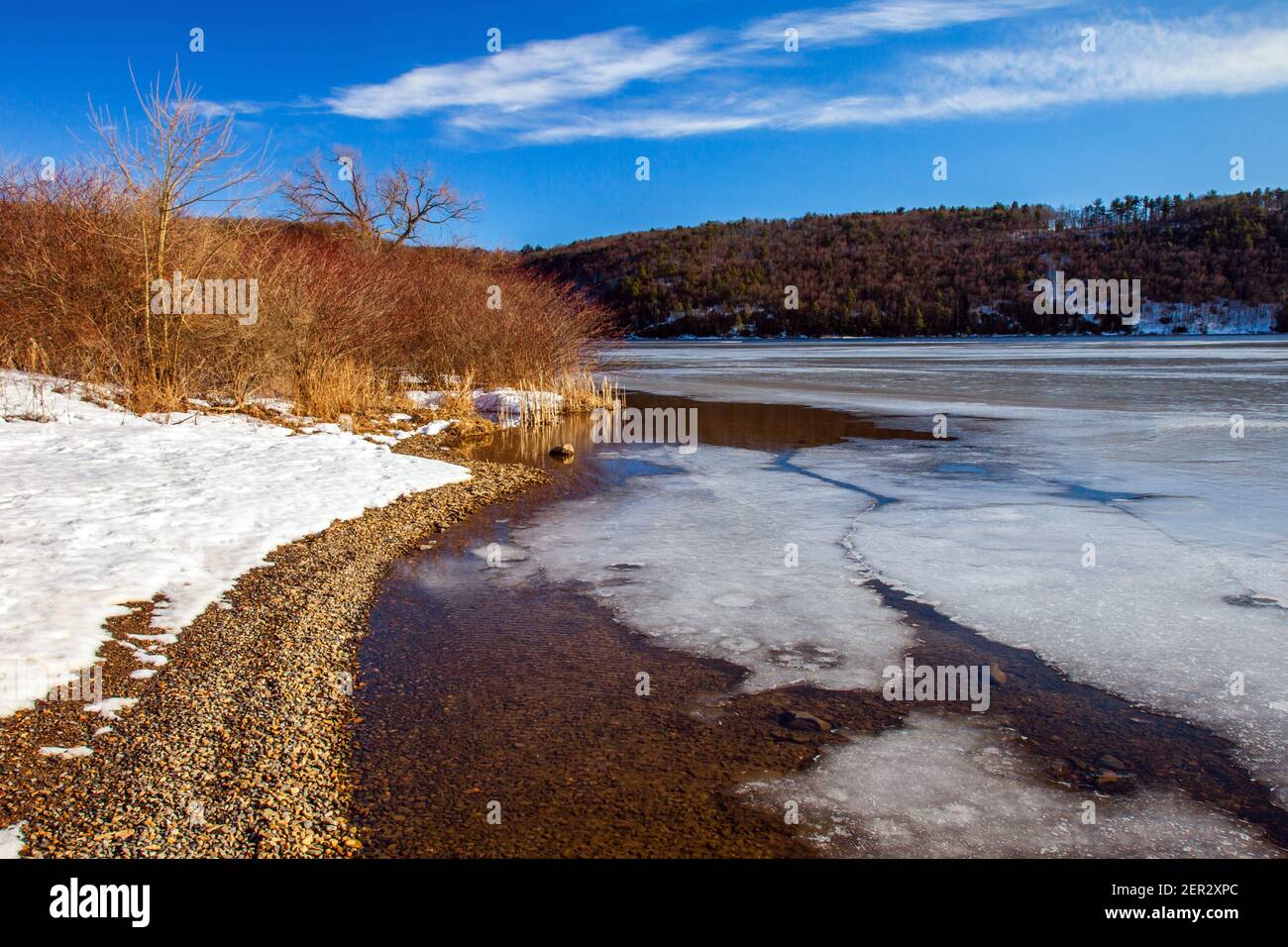 A late winter sun creating solar warming causing snow and ice melt along the shore of Beltzville Lake in Carbon County, Pennsylvania Stock Photo