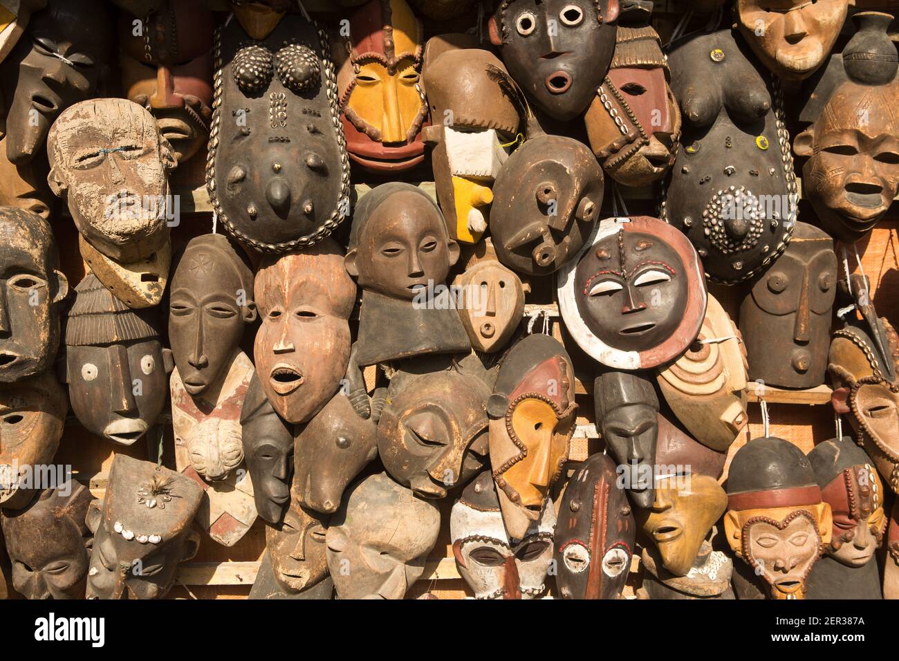 Traditional african masks hanging for sell in a market stall Stock