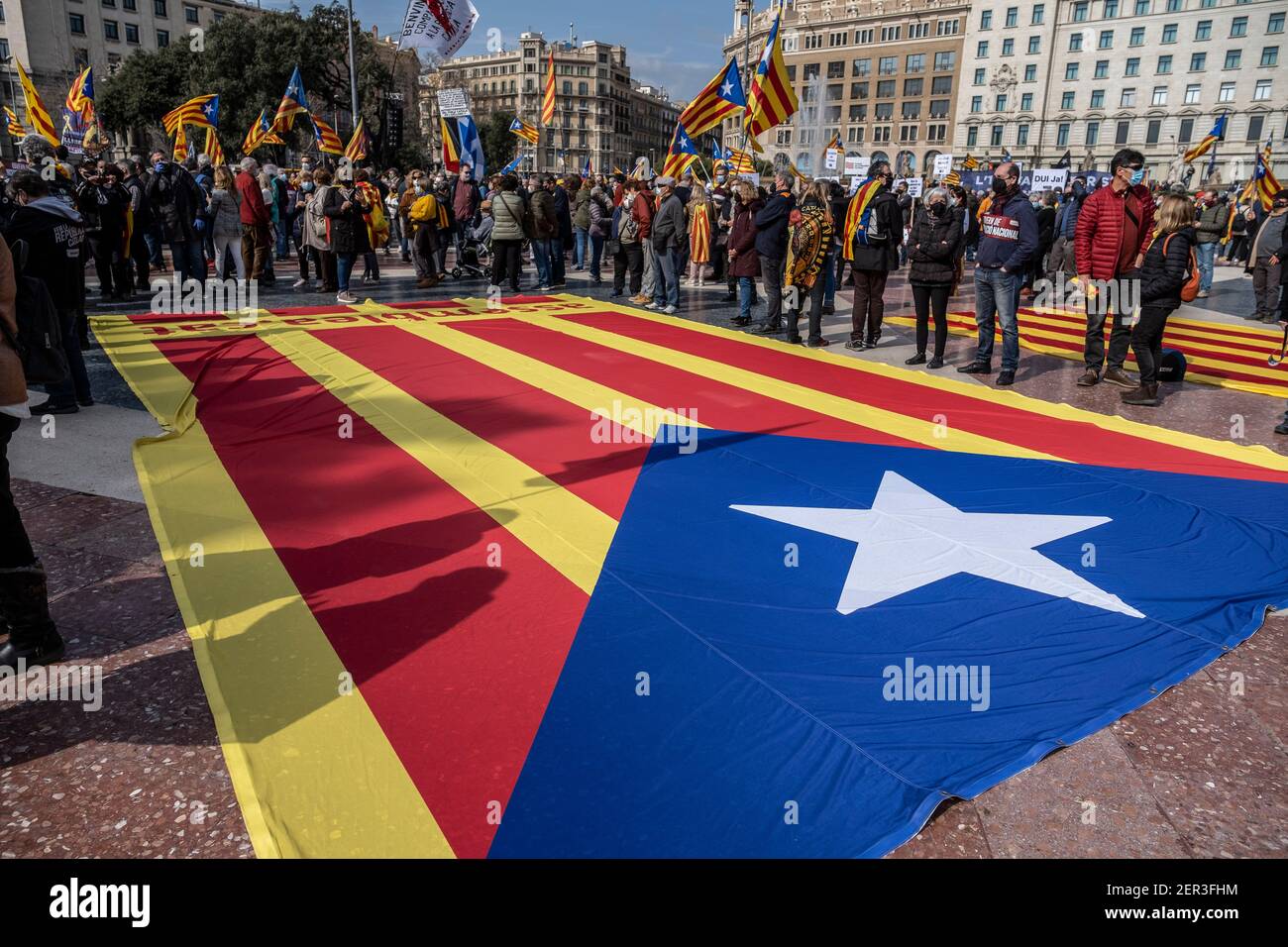 A large pro-independence flag is seen on the floor of Plaza Catalunya during the demonstration.Summoned by the independentist civil entity Assemblea Nacional Catalana (ANC) and under the slogan for the national social urgency, hundreds of people have gathered in Plaza Catalunya to ask the government of concentration that represents the majority of the 52% reached at the polls. Stock Photo