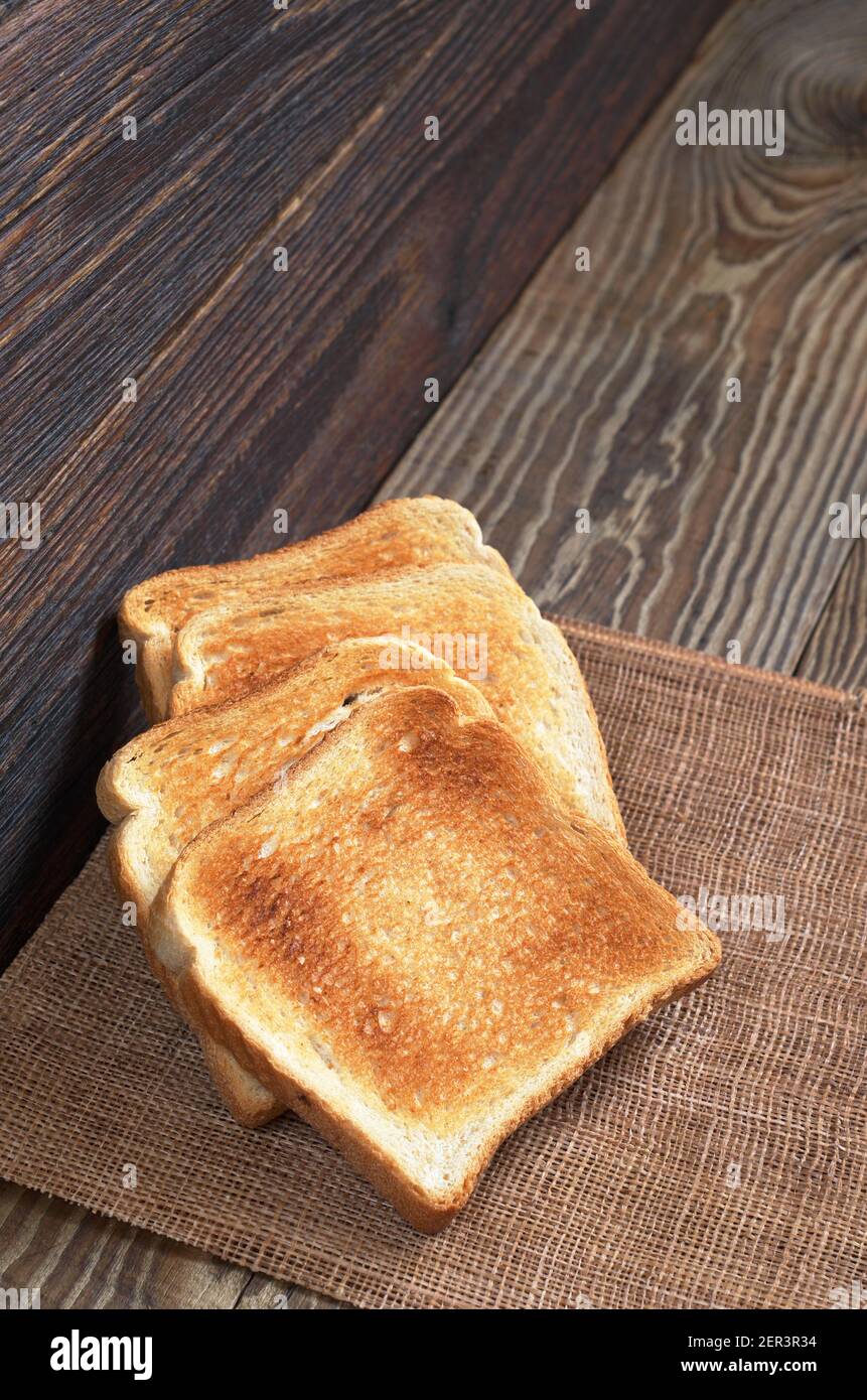 Slices of toasted bread on old wooden table. Vertical photo Stock Photo ...