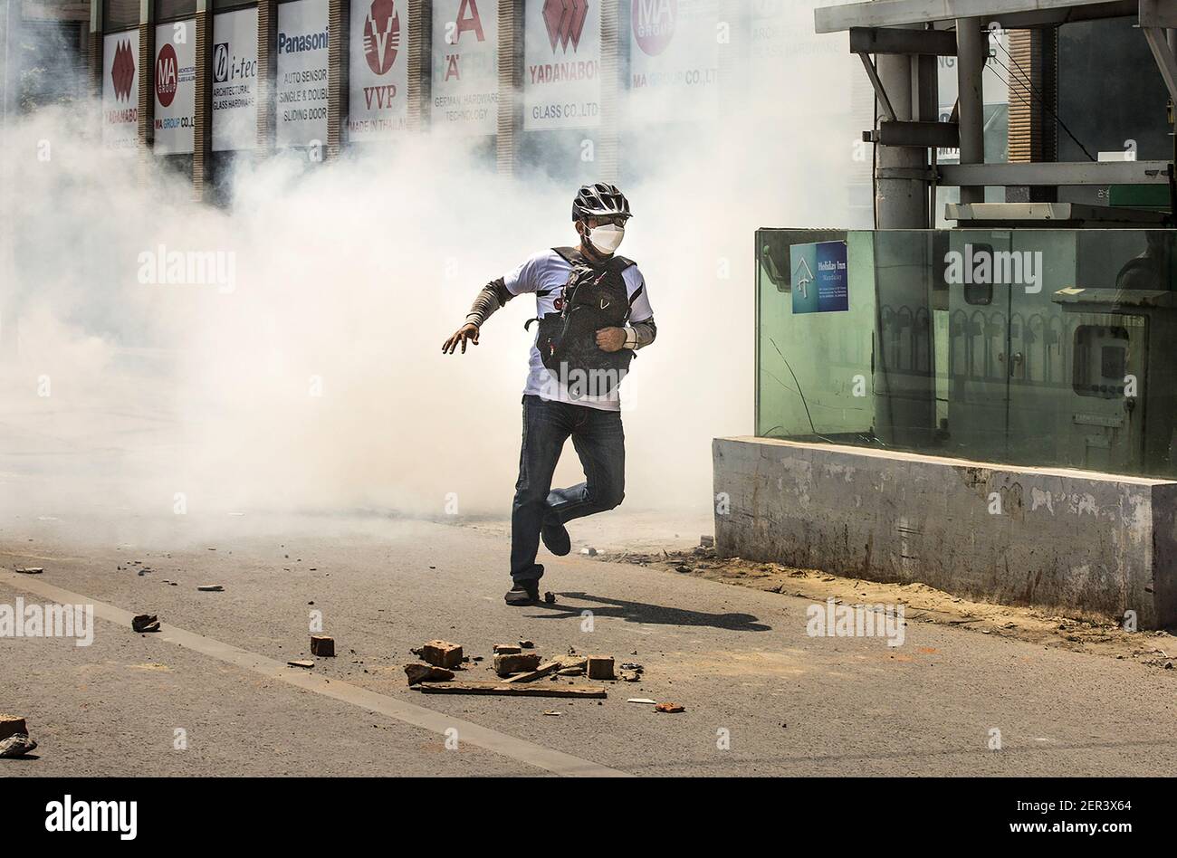 Mandalay, Myanmar. 28th Feb, 2021. A protester runs as police fire tear gas during a protest against the military coup in Mandalay, Myanmar, Sunday, February. 28, 2021. Security forces continue to crackdown on demonstrations against the military coup. Photo by Xiao Long/UPI Credit: UPI/Alamy Live News Stock Photo