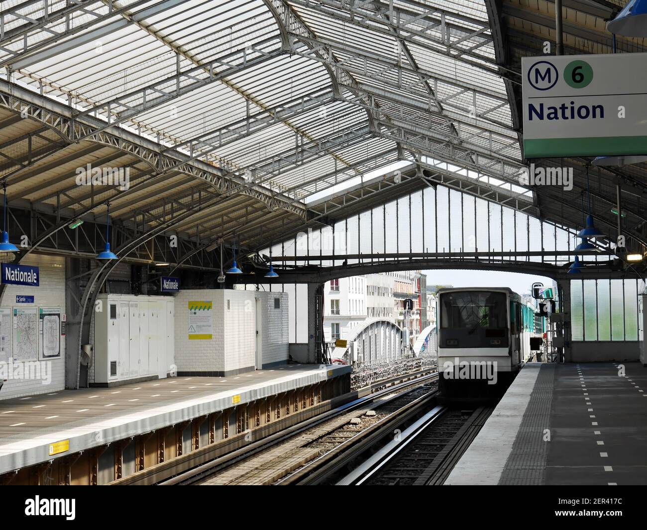 Metro station 'Nationale' in Paris. The train departs from the platform. Maps, direction of movement are visible on the walls. Stock Photo