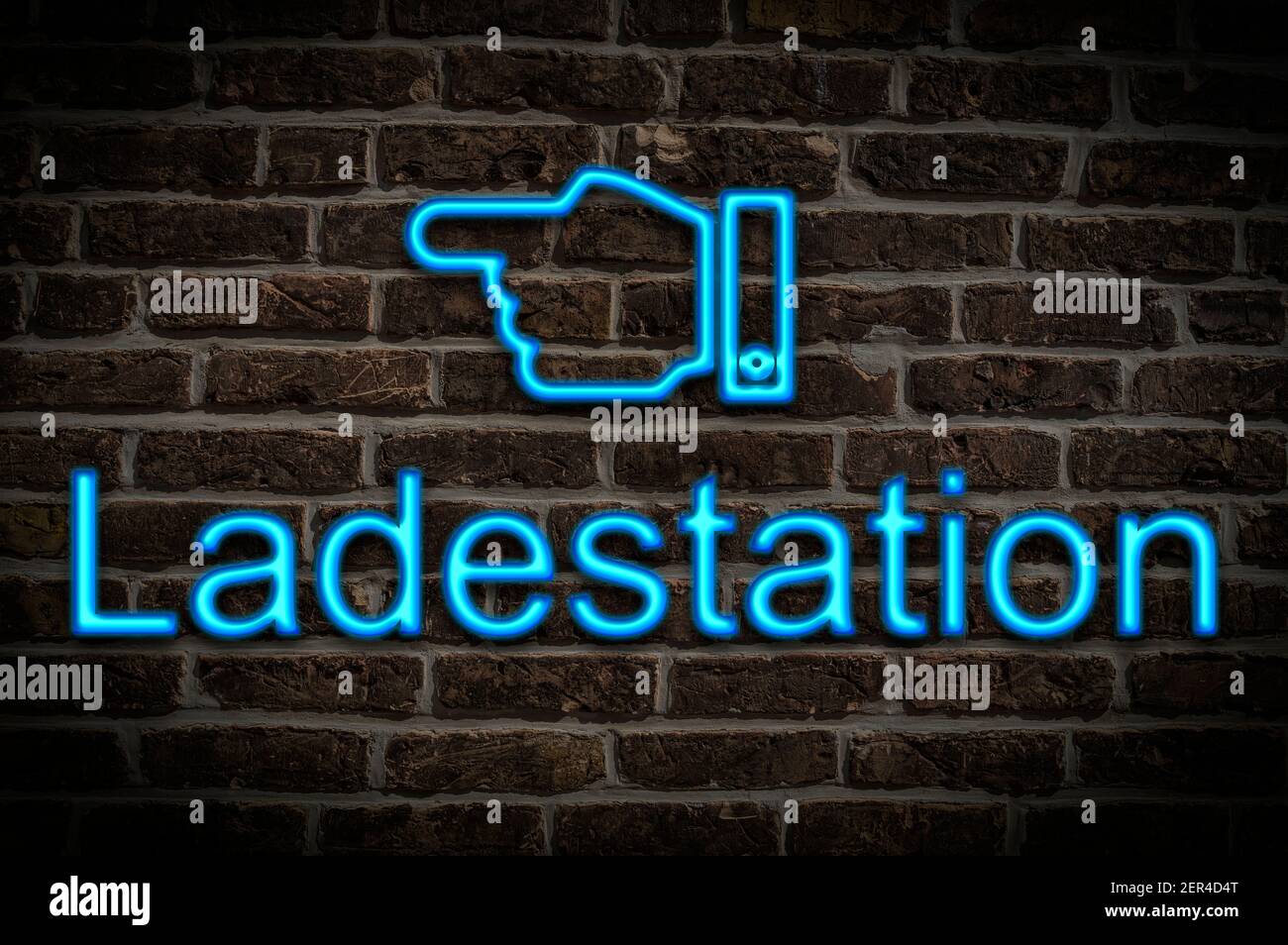 Detail photo of a neon sign on a wall with the inscription Ladestation (Charging station) Stock Photo
