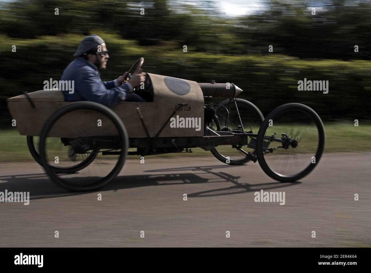 man racing full speed on countryside road with 1919 Grafton cycle car Stock Photo