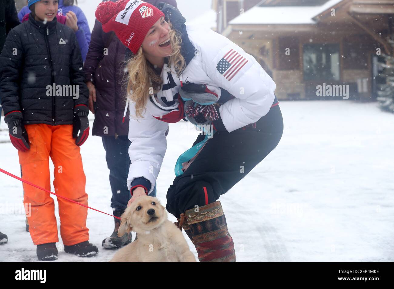 Jessie Diggins, Team USA Olympic gold medalist cross country skier, bends down to greet Lily, a 12 week-old golden retriever, as hundreds brave snowy, blustery weather to honor Diggins with a parade on Saturday, April 14, 2018, in Stillwater, Minn. (Photo by David Joles/Minneapolis Star Tribune/TNS/Sipa USA) Stock Photo