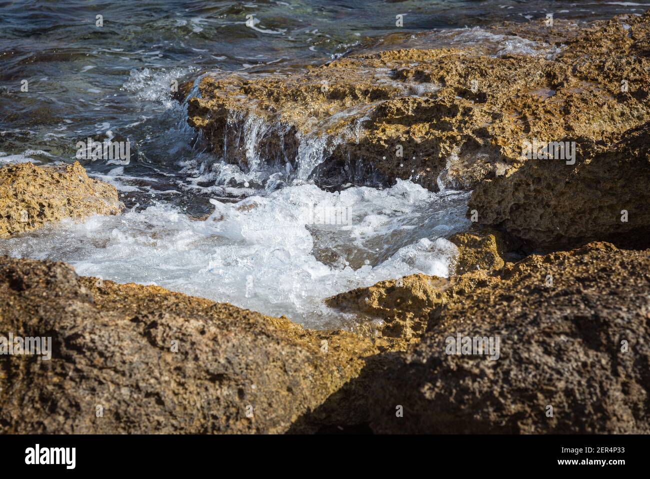 Sea foam from waves breaking against the rocks Stock Photo - Alamy
