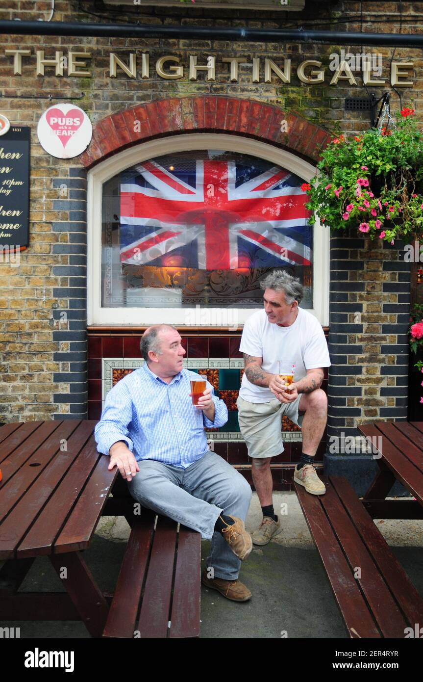 Two men chatting outside The Nightingale pub, Balham, London Stock Photo