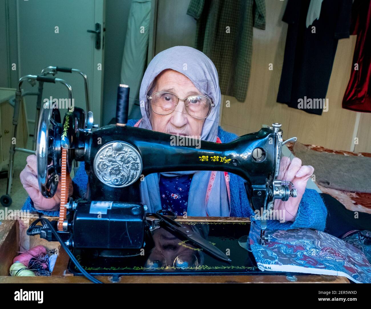 Arabic muslim old woman using old sewing machine Stock Photo