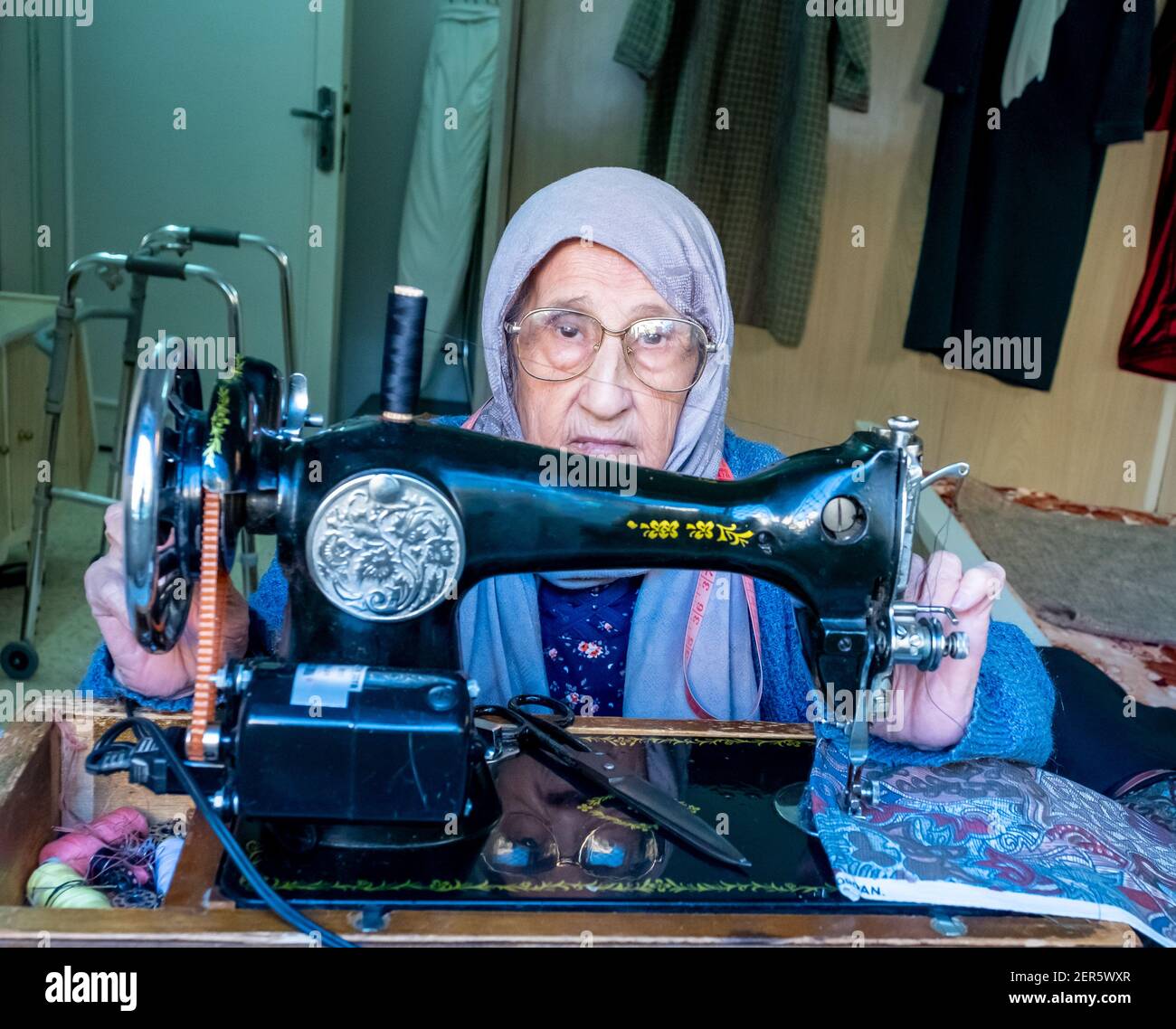 Arabic muslim old woman using old sewing machine Stock Photo
