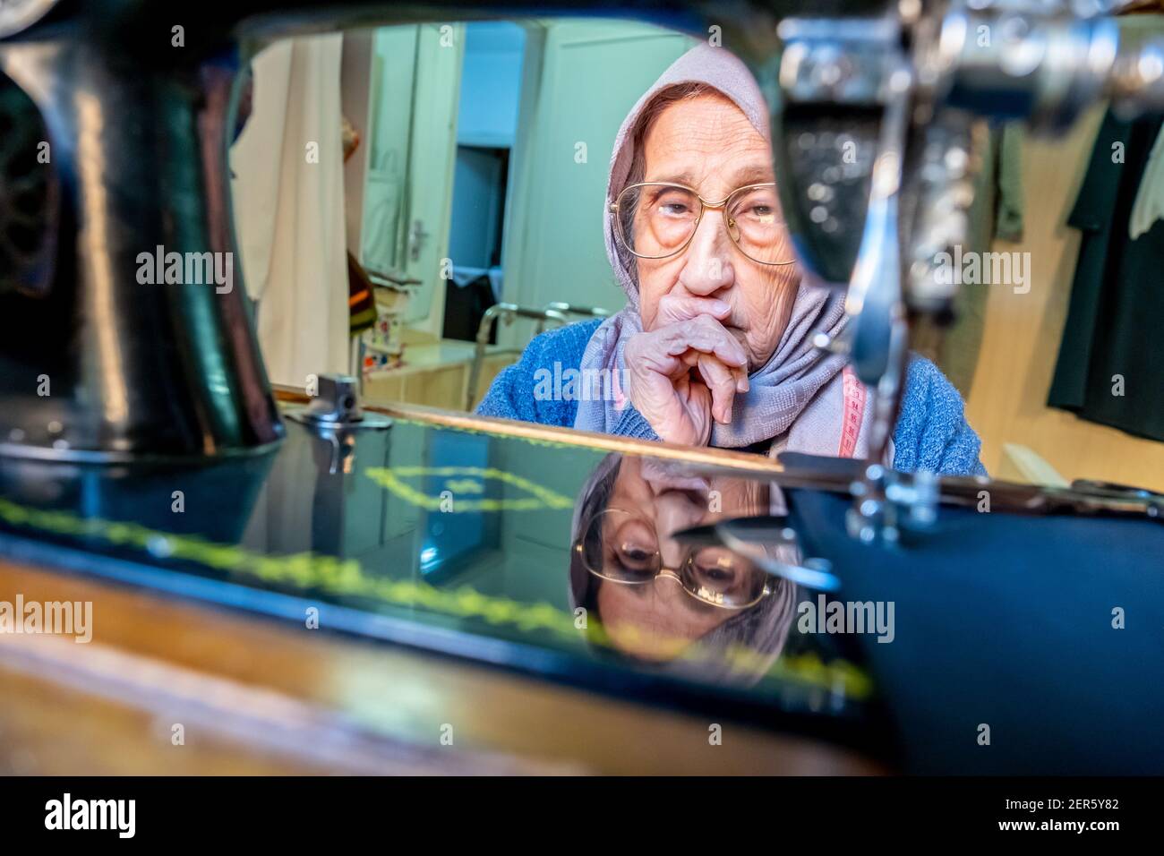 Arabic muslim old woman using old sewing machine Stock Photo