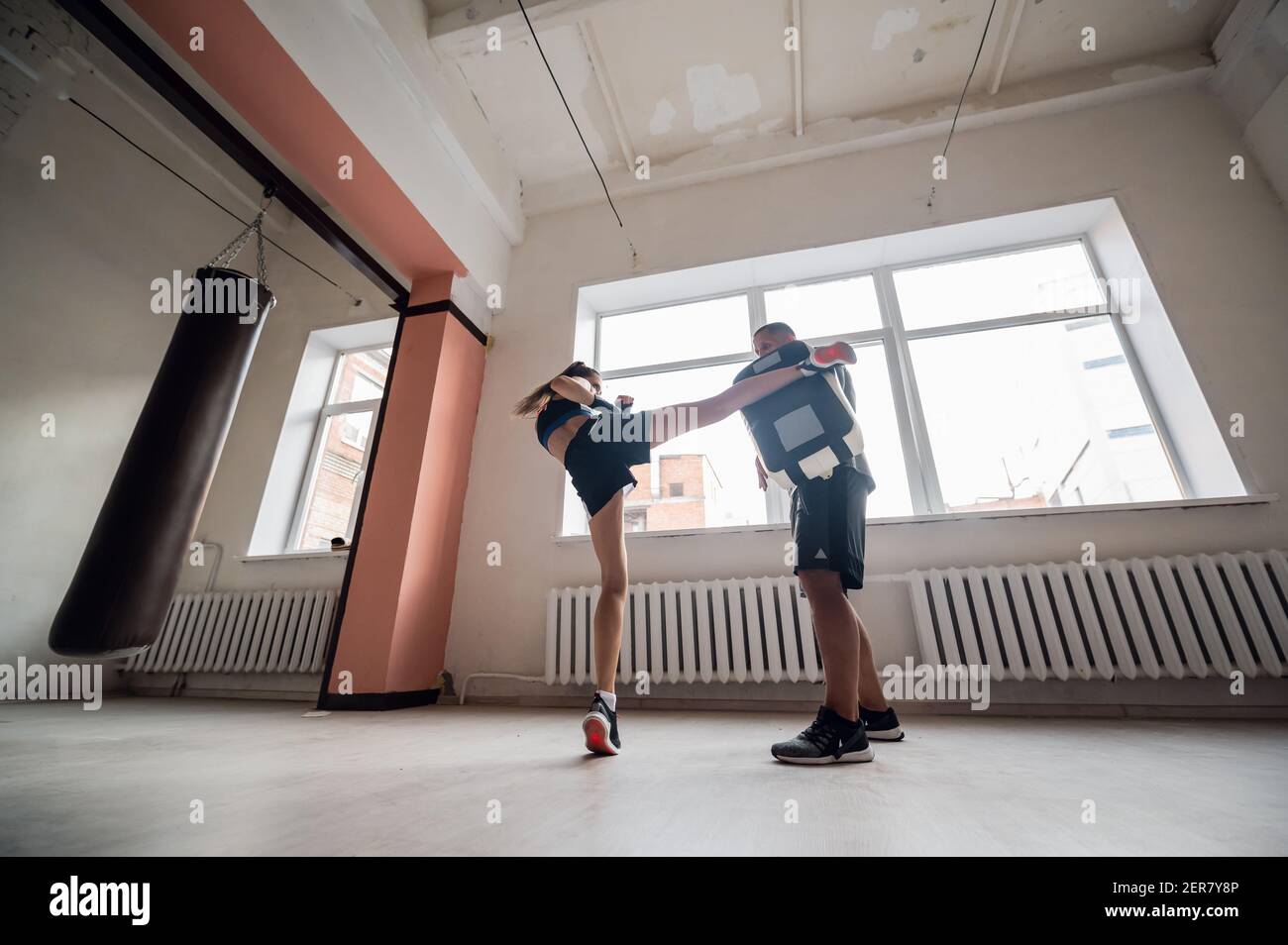Female martial arts fighter practicing leg kick or high kick with her