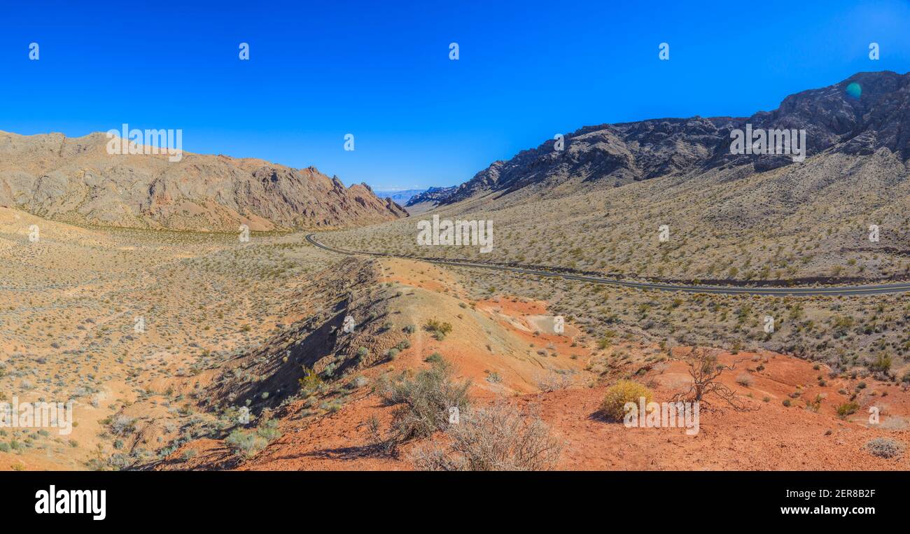 Panoramic image of the Arizona desert taken from elevated position in blue skies during the day with road in the foreground photographed in the USA in Stock Photo