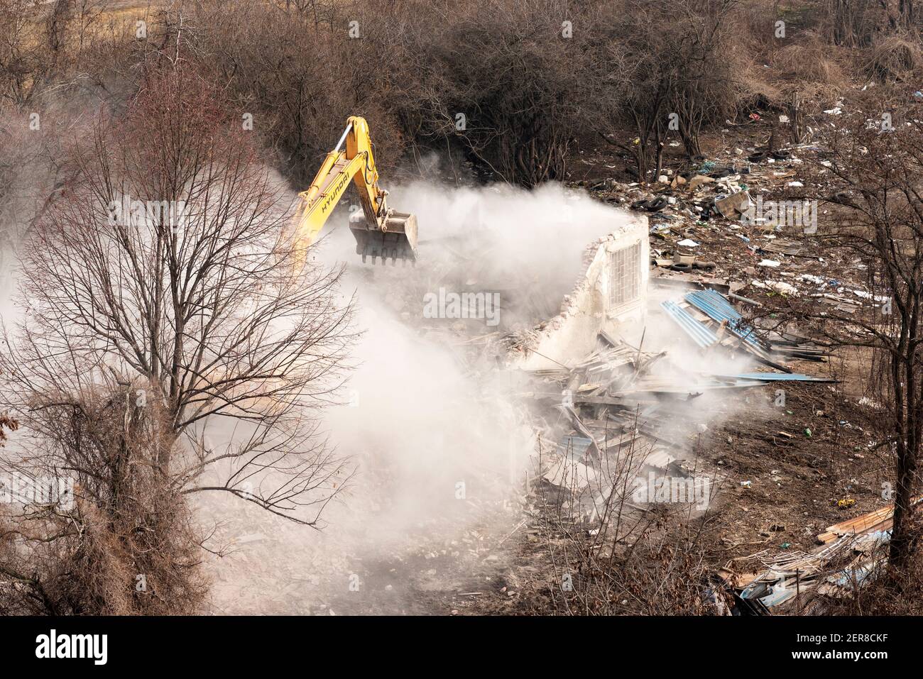 Building demolition Hyundai digger demolishing an old residential house and clearing a construction site in Sofia, Bulgaria, Eastern Europe, EU Stock Photo