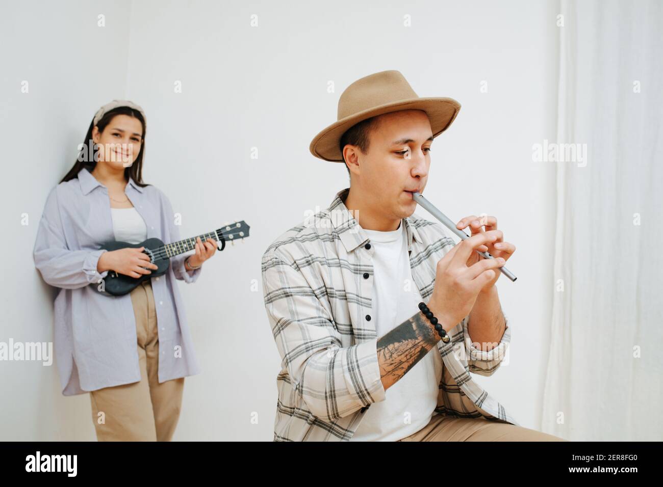 A man plays the Irish flute, and girl playing on a ukulele Stock Photo